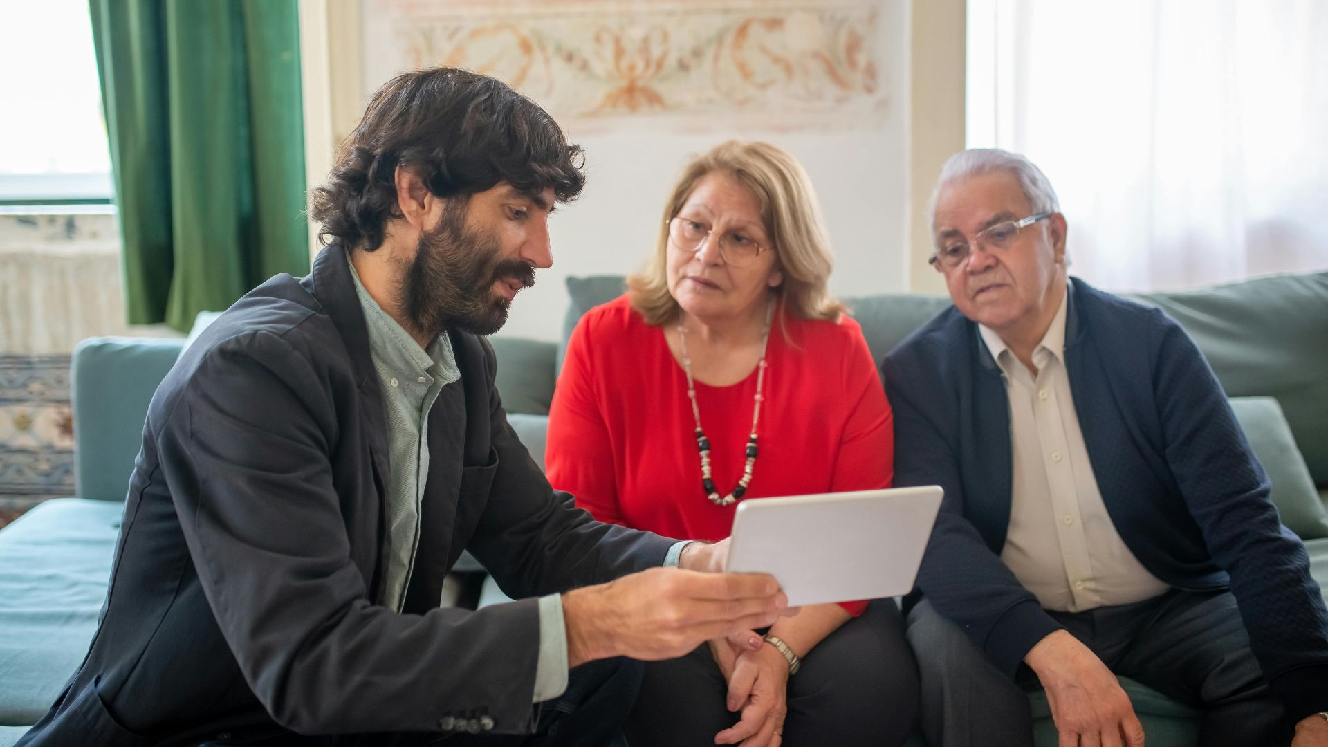 A financial advisor discussing investment options with an elderly couple in a cozy living room.