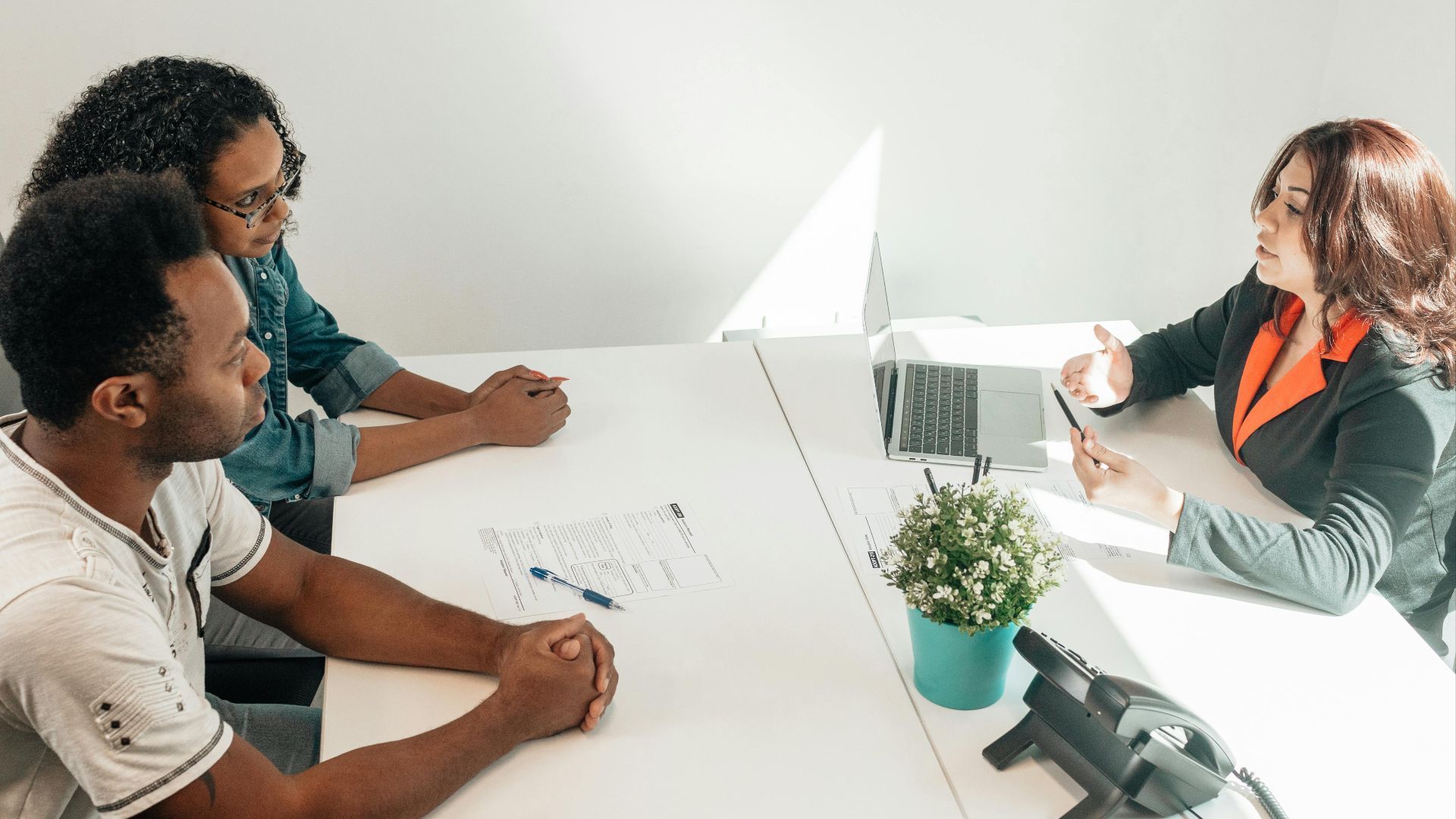 Two adults consulting a legal advisor in a modern office setting.