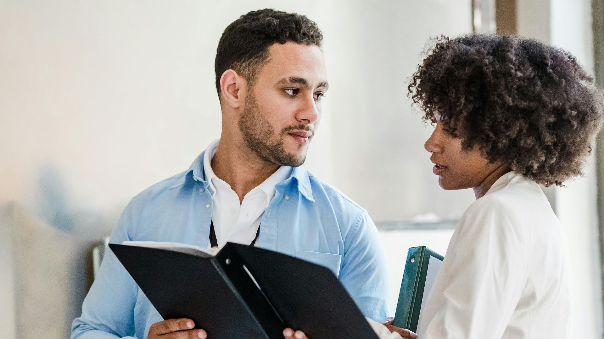 Business professionals discussing documents in a modern office setting.