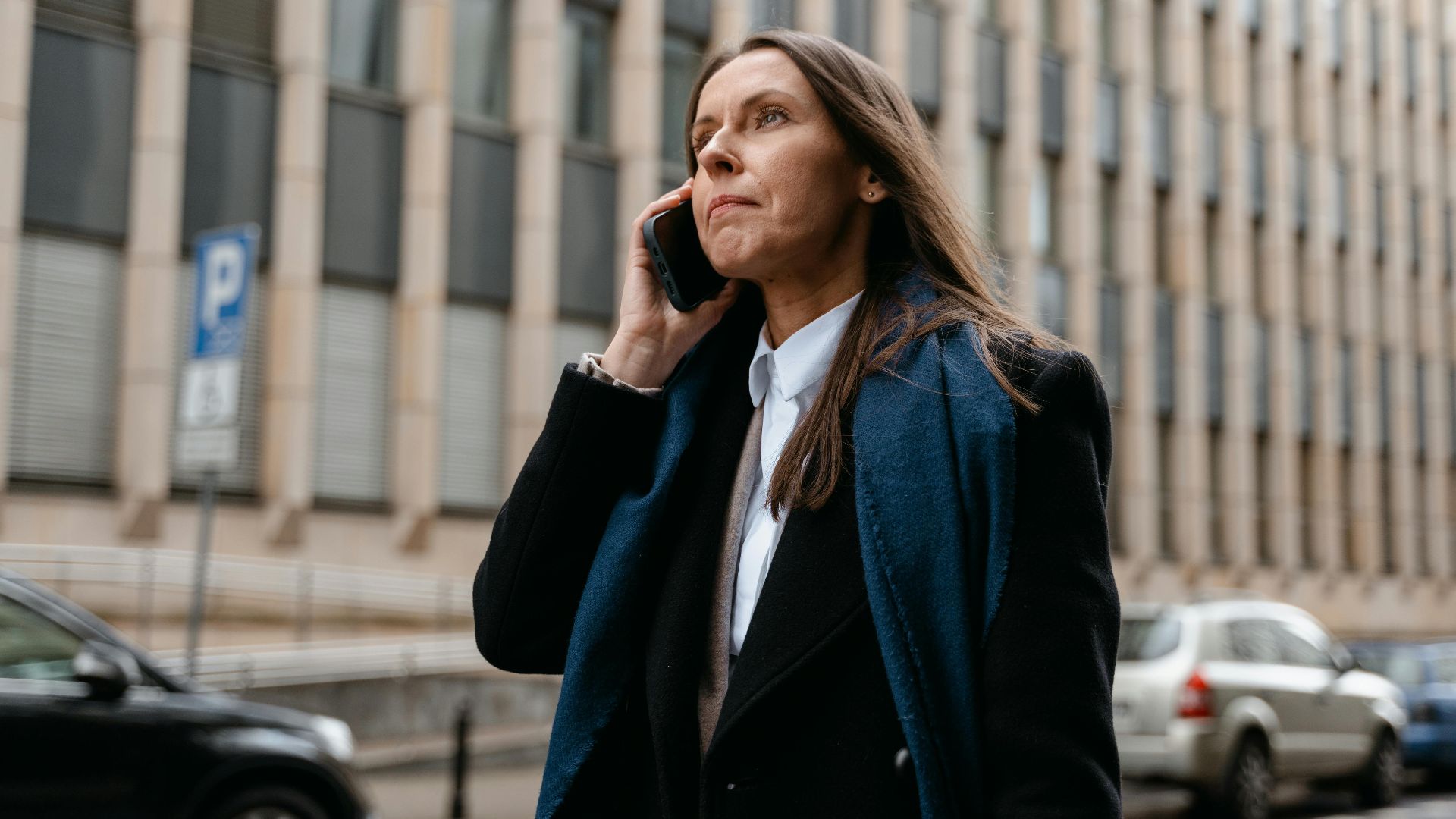 Confident businesswoman talking on the phone in the city street.