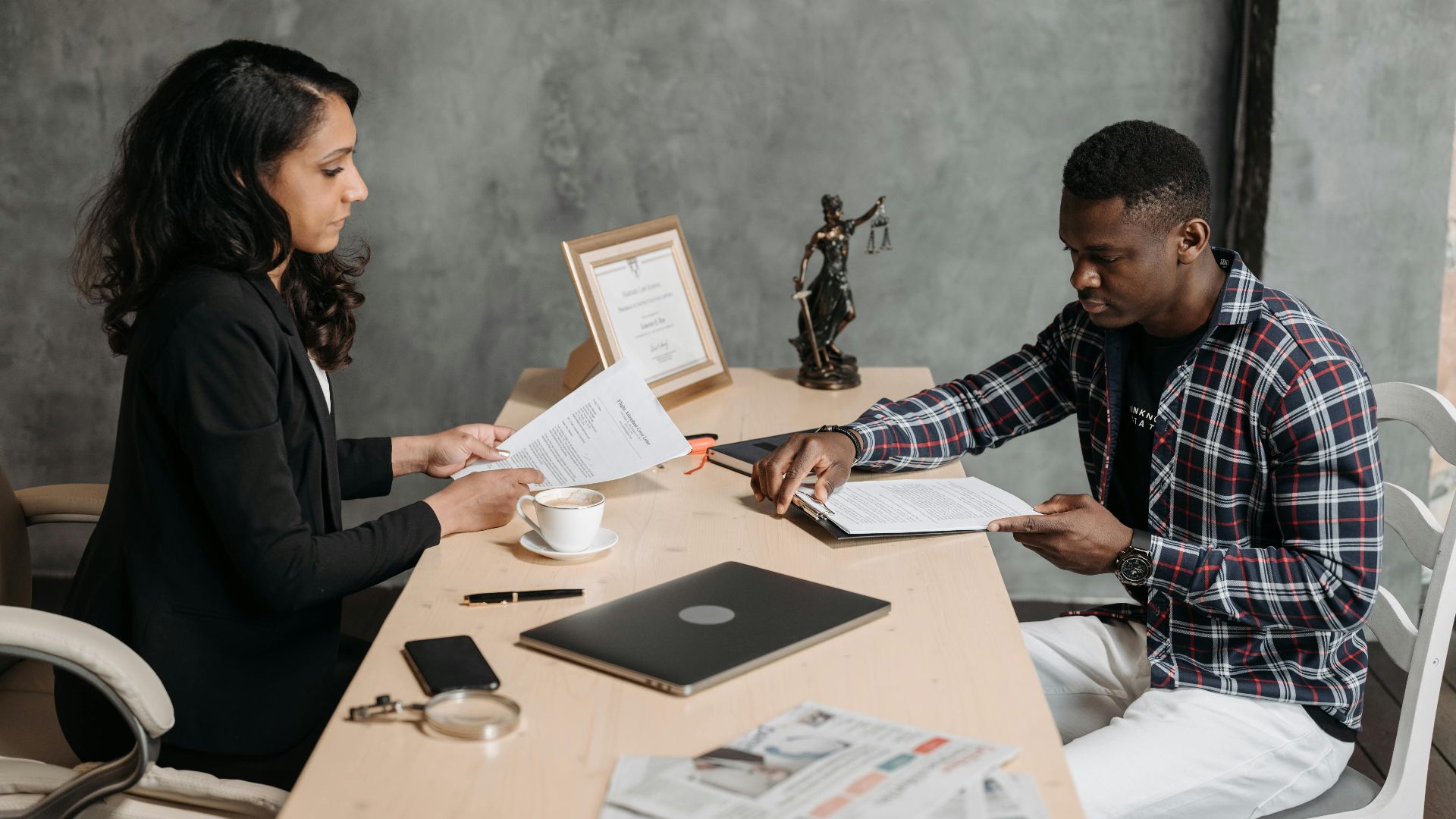 Business professionals discussing documents in a modern office setting.