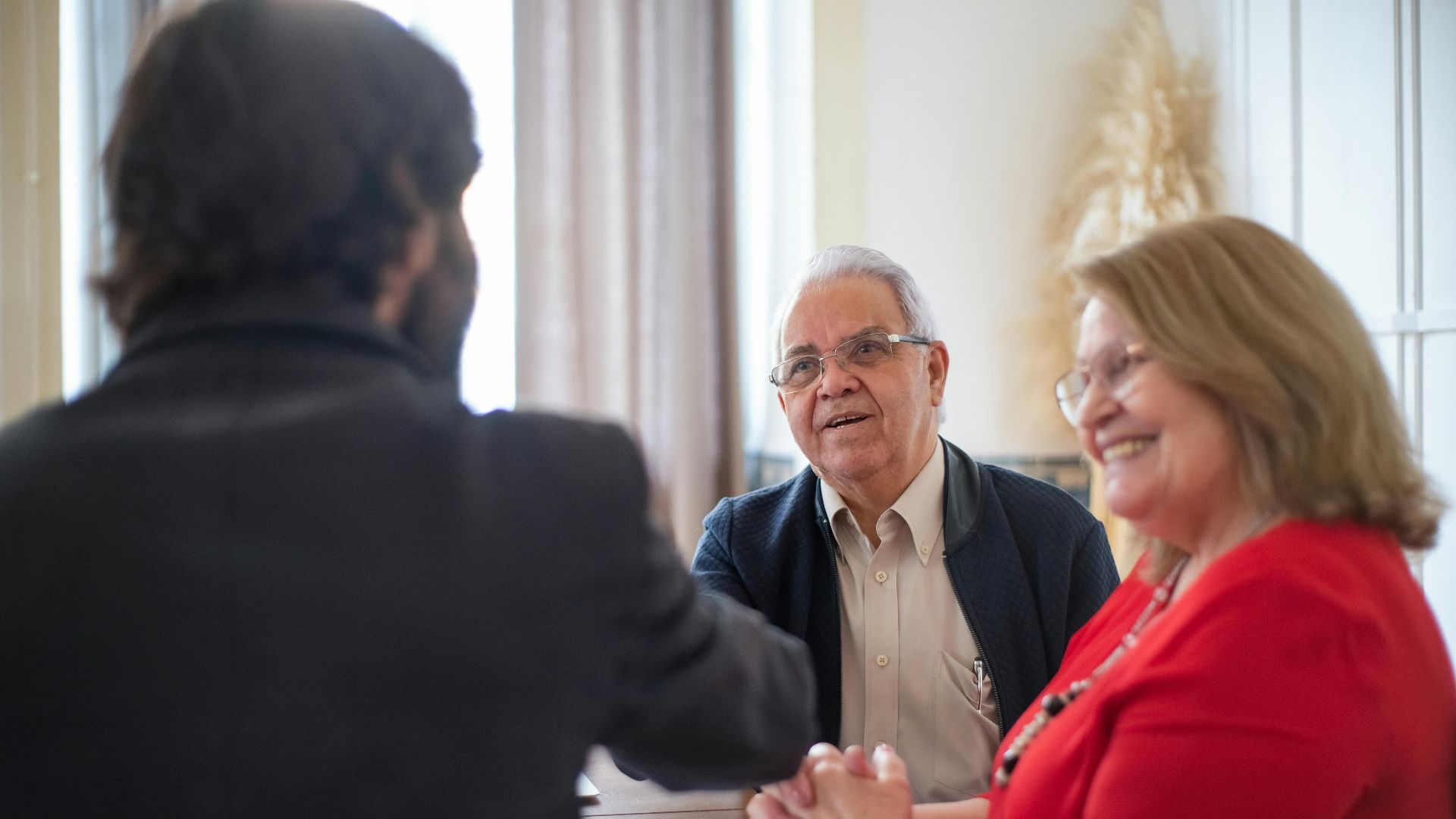 Senior couple meeting with a professional at a bright interior space, showcasing a positive and engaging discussion.
