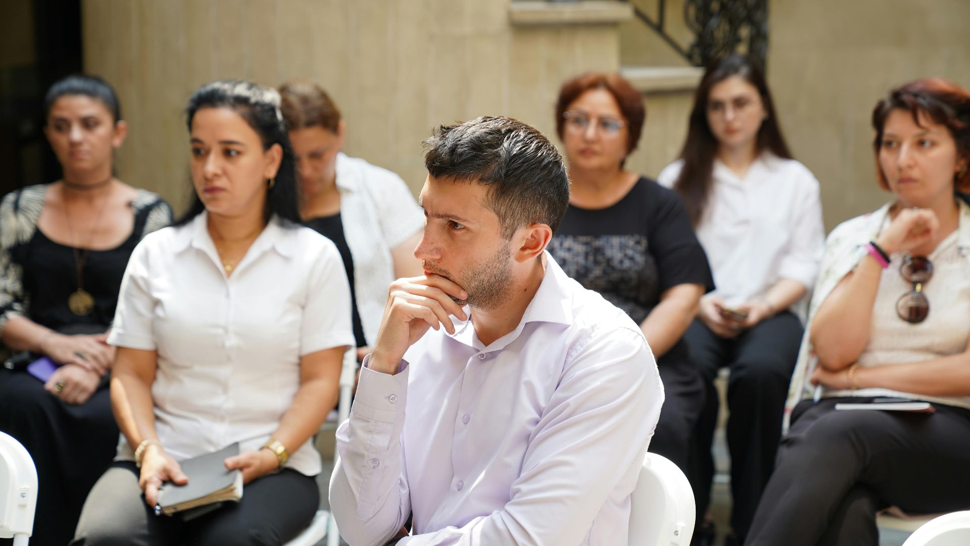 Group of people engaged in a business meeting discussion outdoors.