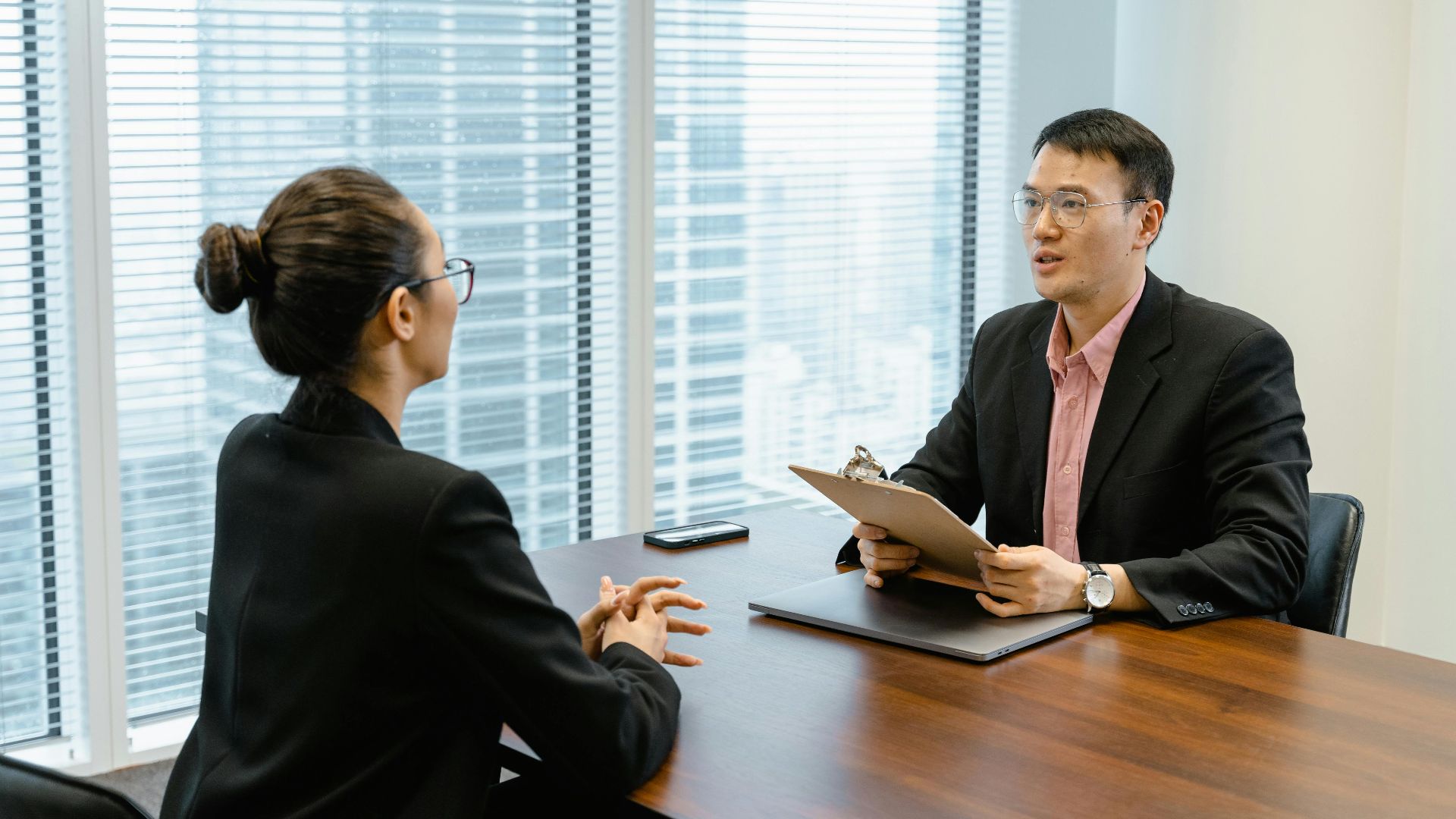 Professional business meeting in a modern office with two people discussing over documents.