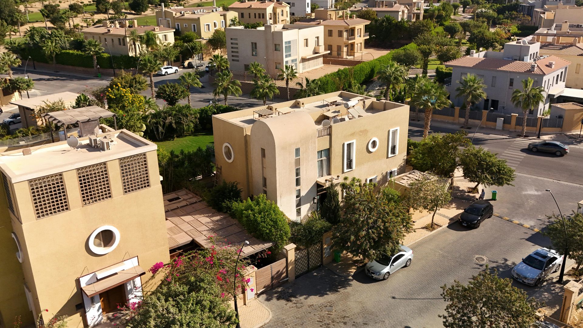 Aerial image showcasing modern villas and greenery in a luxury community in West Cairo, Egypt, perfect for real estate insights.