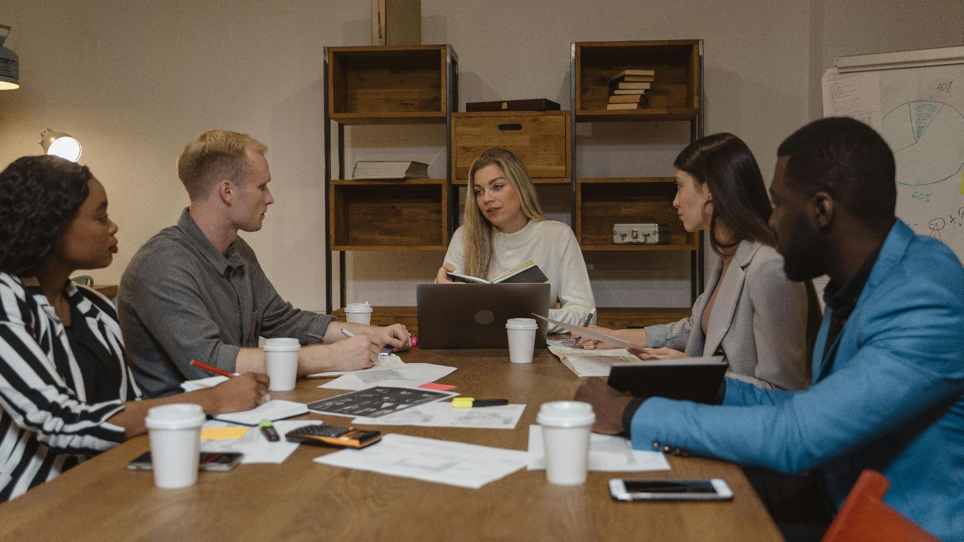 Business team discussing strategies in a modern office setting, focusing on collaboration.