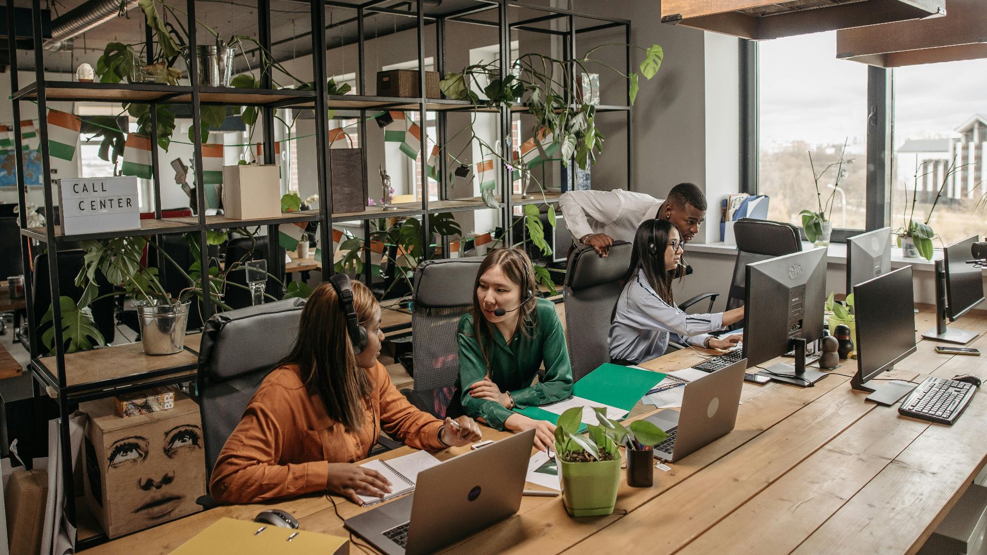 Group of diverse call center professionals working and collaborating in a modern office setting.