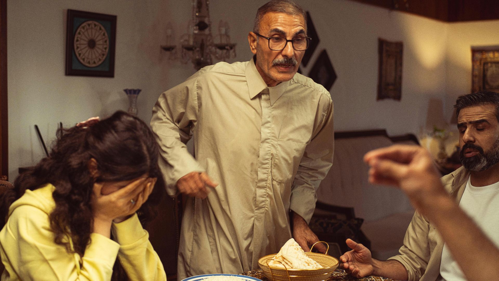 A family gathered around a dining table having an intense emotional exchange.