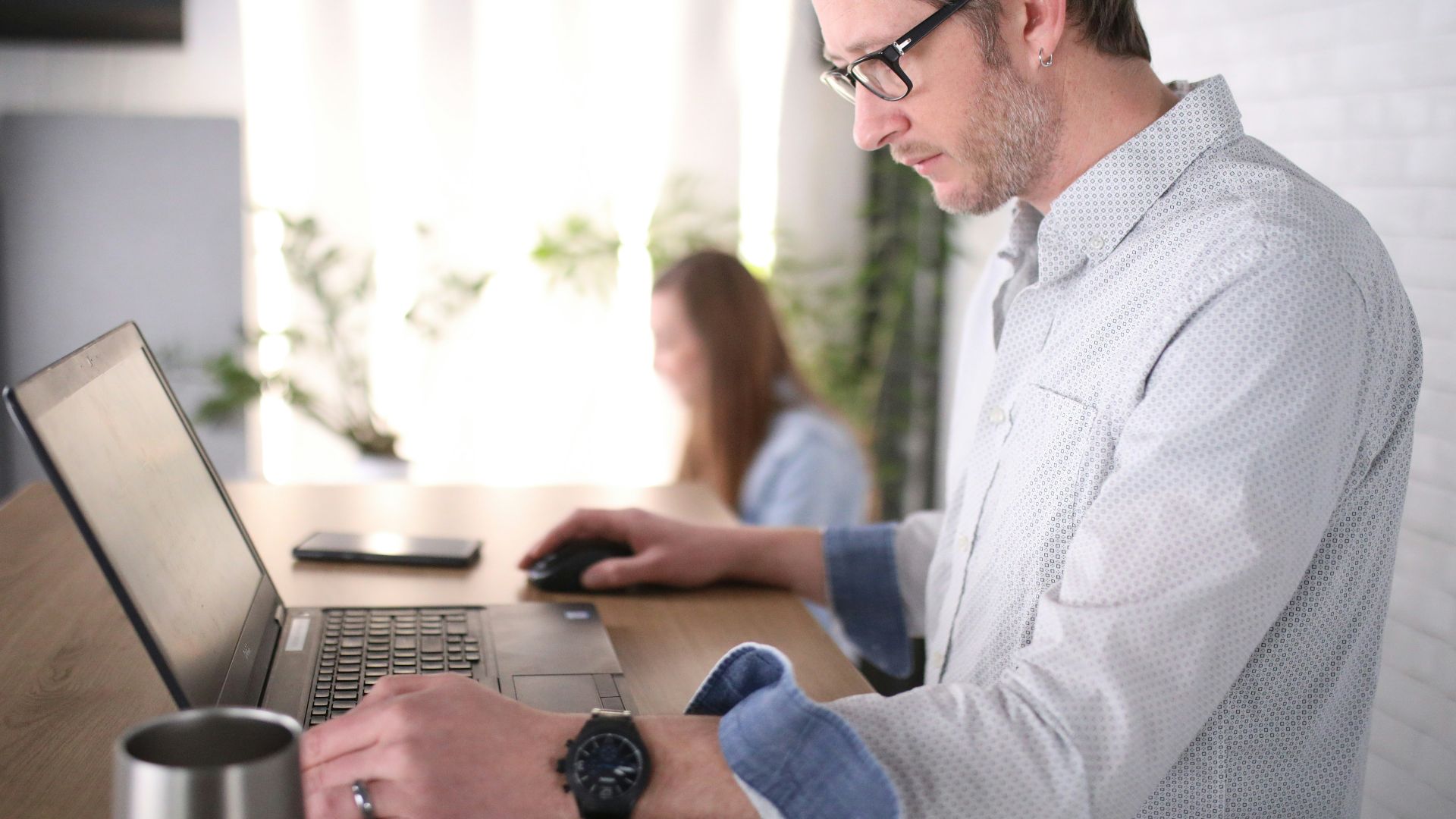 man in blue dress shirt using computer