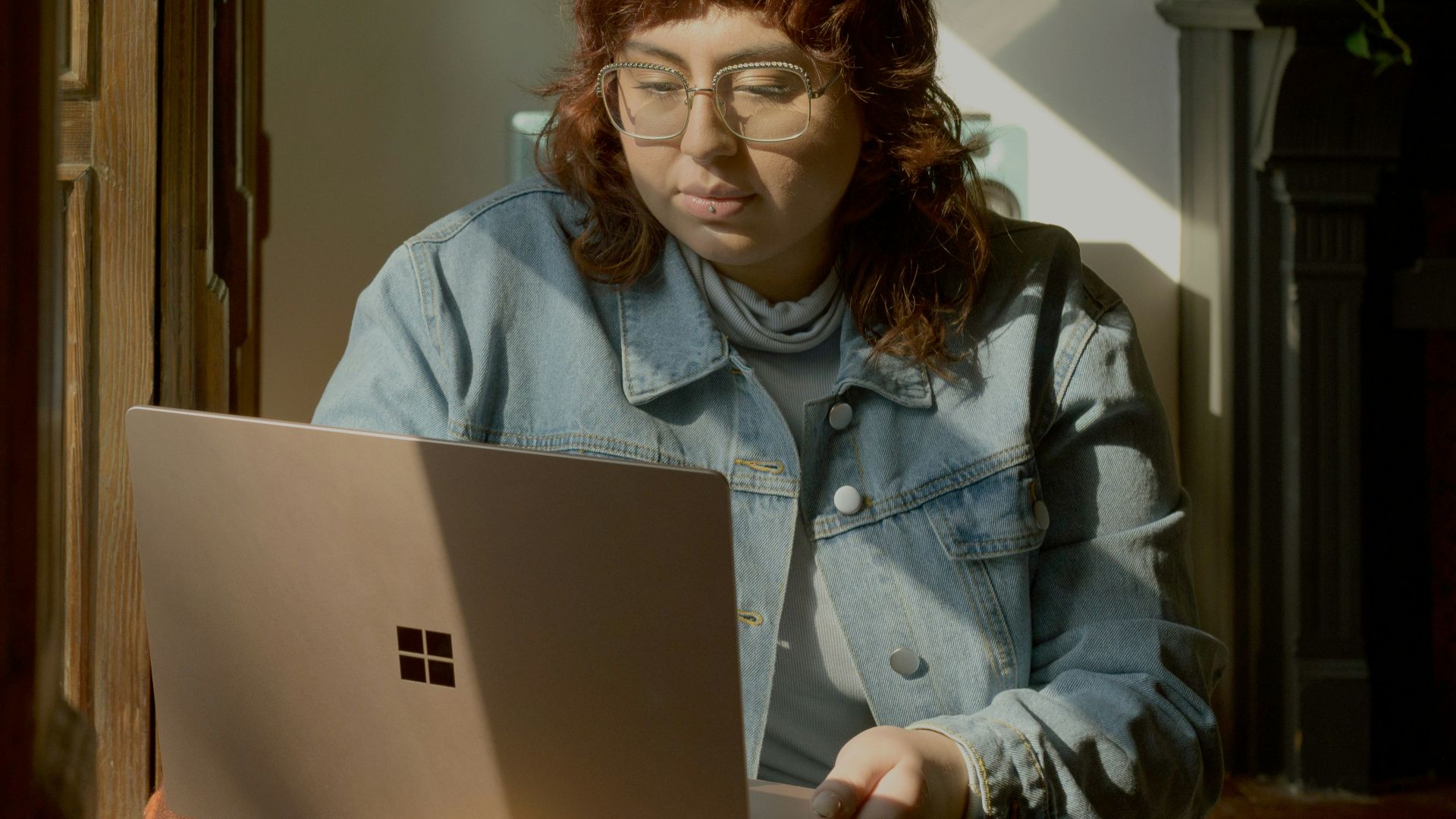 two women sitting on a bed looking at a laptop