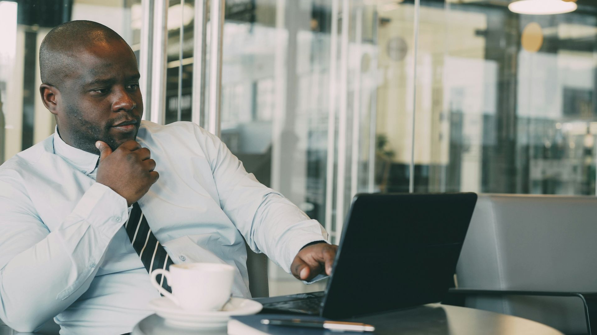Man in shirt and tie working on laptop