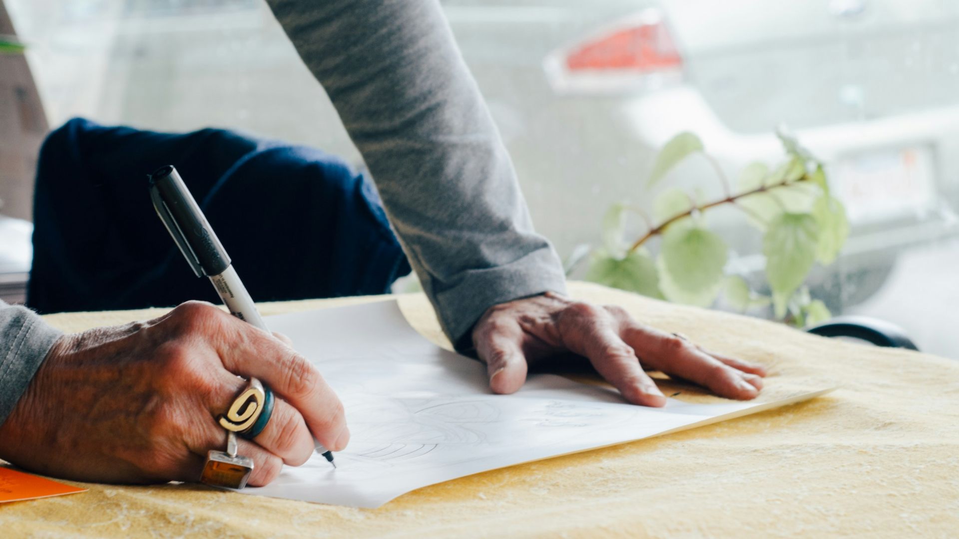person writing on white plain paper on the table photography
