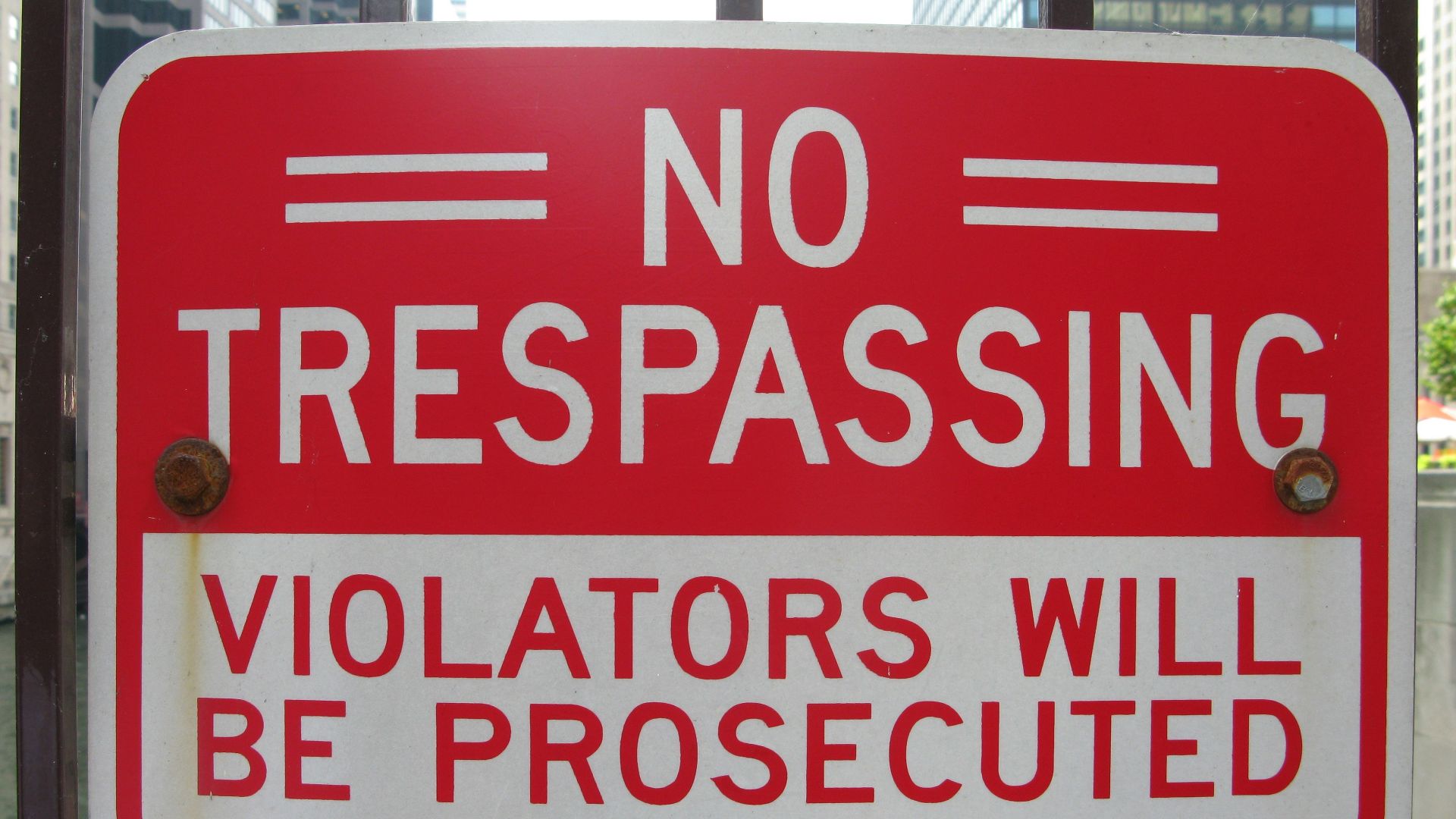 a no trespassing sign posted on a gate
