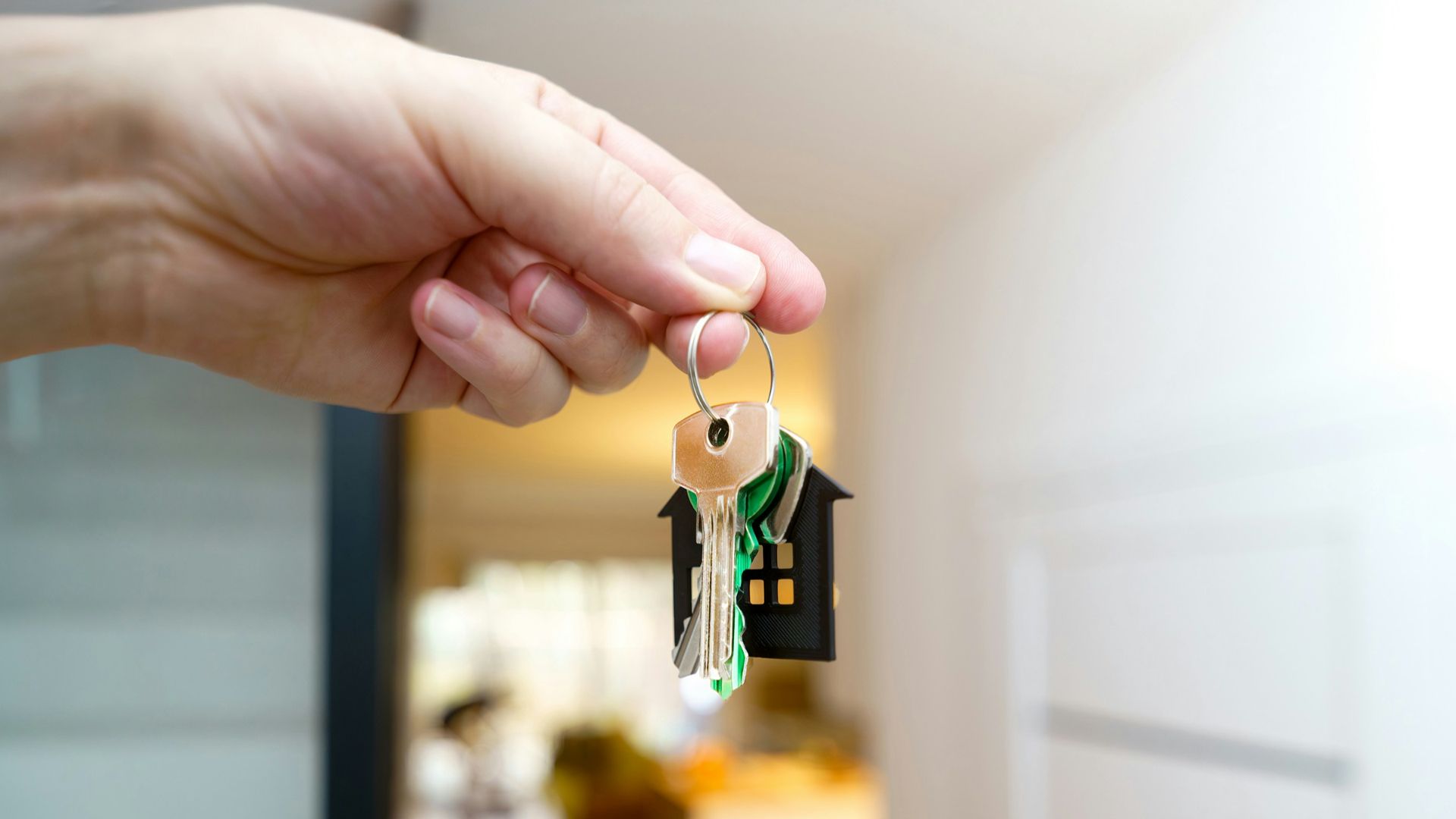 Holding house keys in front of the entrance.