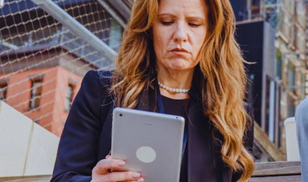 Low Angle Shot of Office Workers Sitting on Wooden Steps in a City and Using Portable Devices