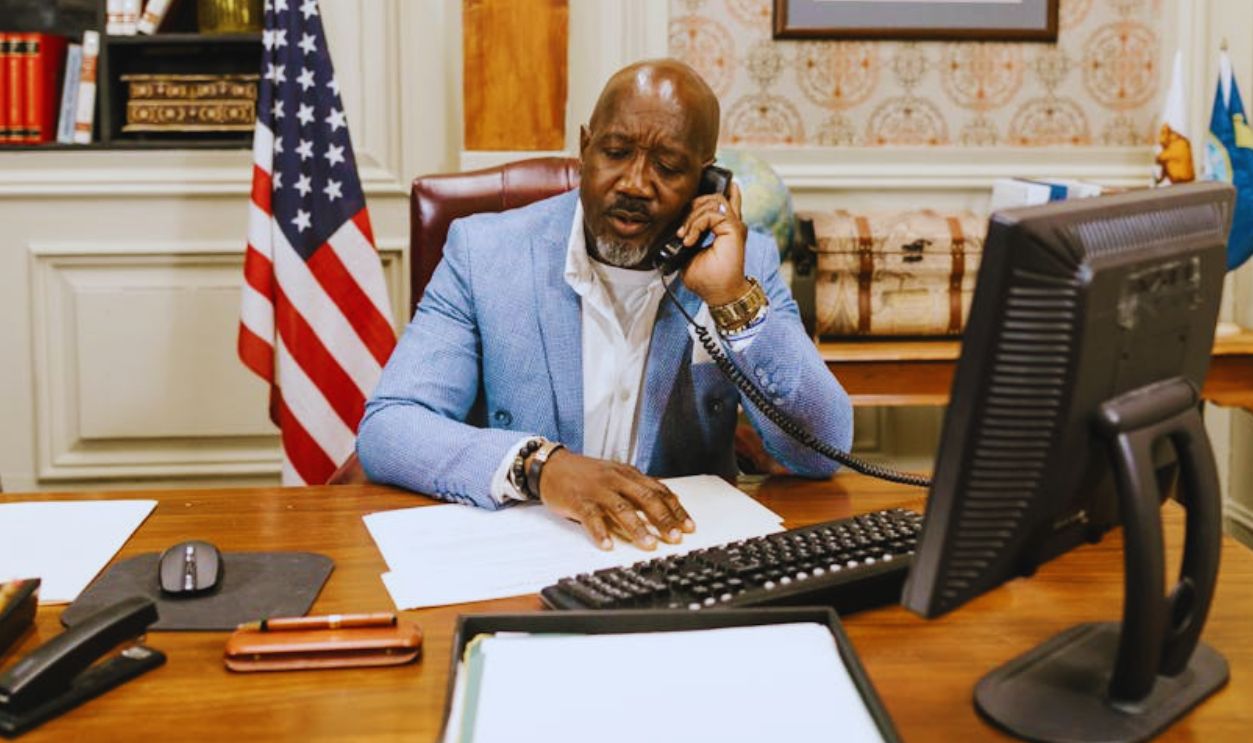 Man in Blue and White Striped Long Sleeve Shirt Sitting on Chair