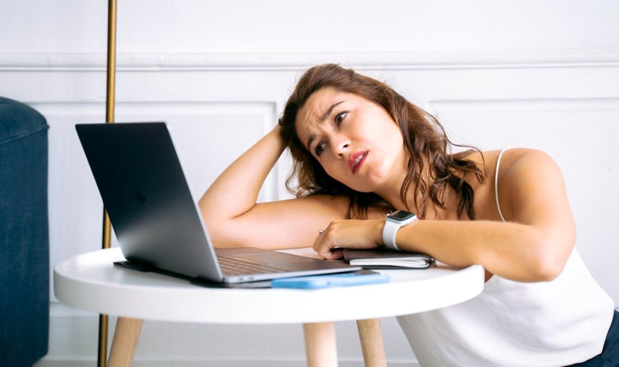Woman in White Top Looking at a Laptop Screen