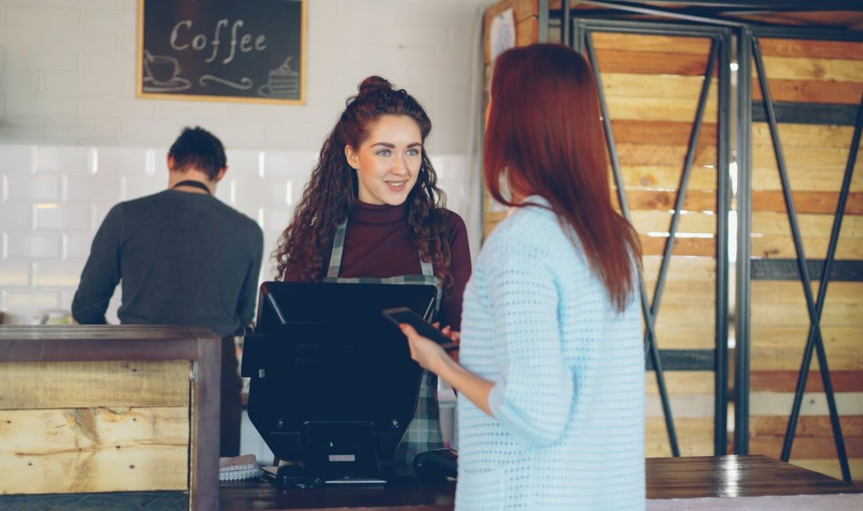 Friendly Barista Serving Customer at a Cafe