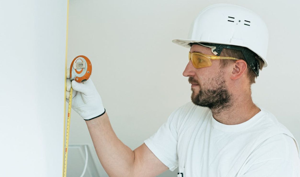 A Man with a Hard Hat Holding a Measuring Tape