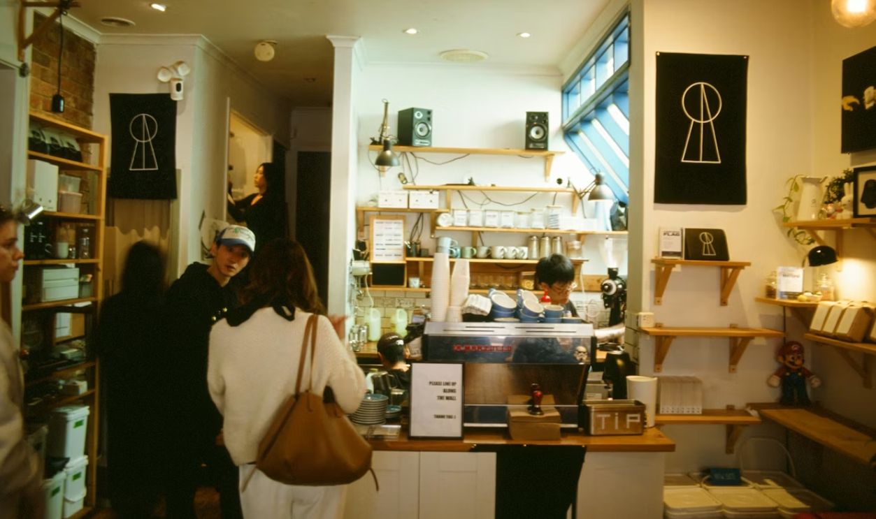 People ordering at a coffee shop counter