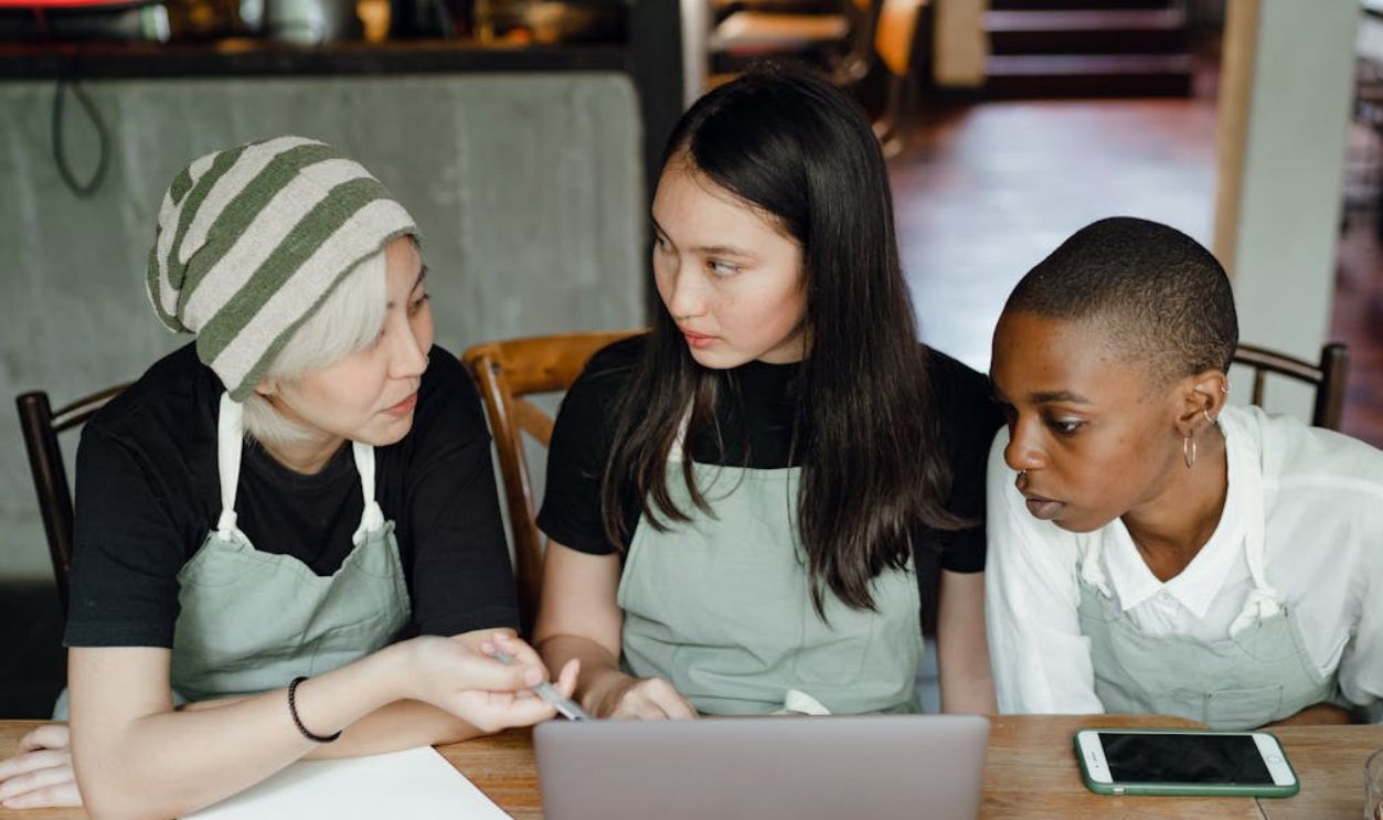 Focused female colleagues working on project on laptop