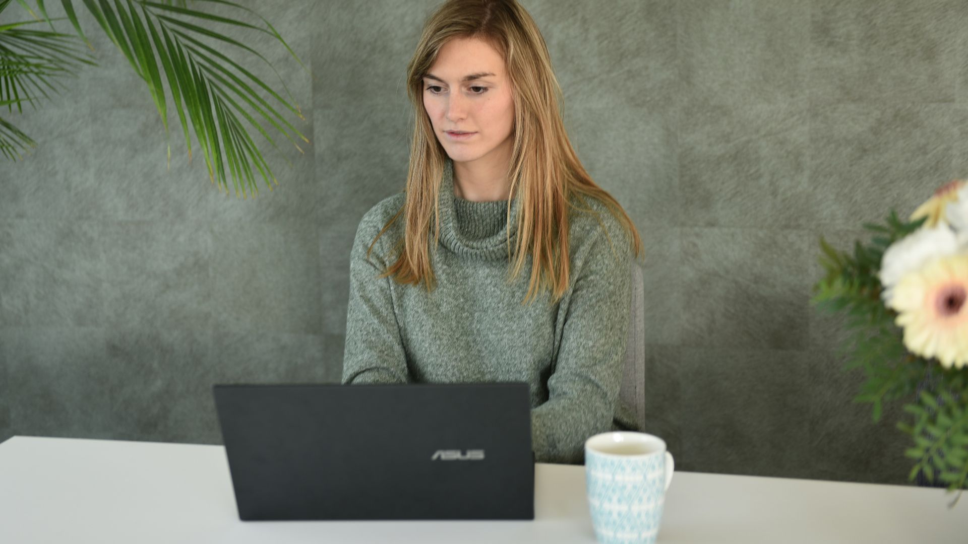 a woman sitting at a table with a laptop
