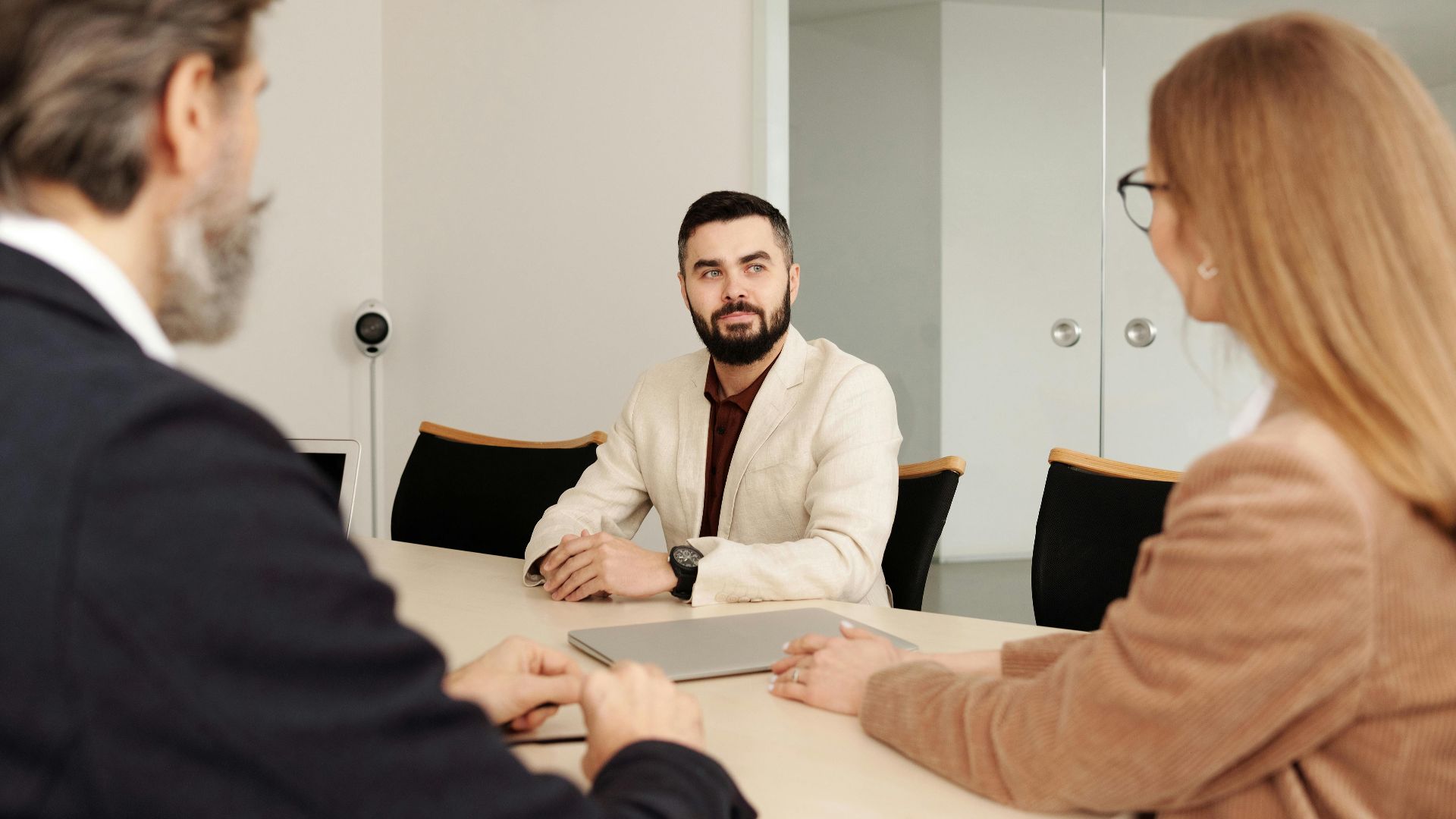 Professional business meeting with diverse team members in an office setting.