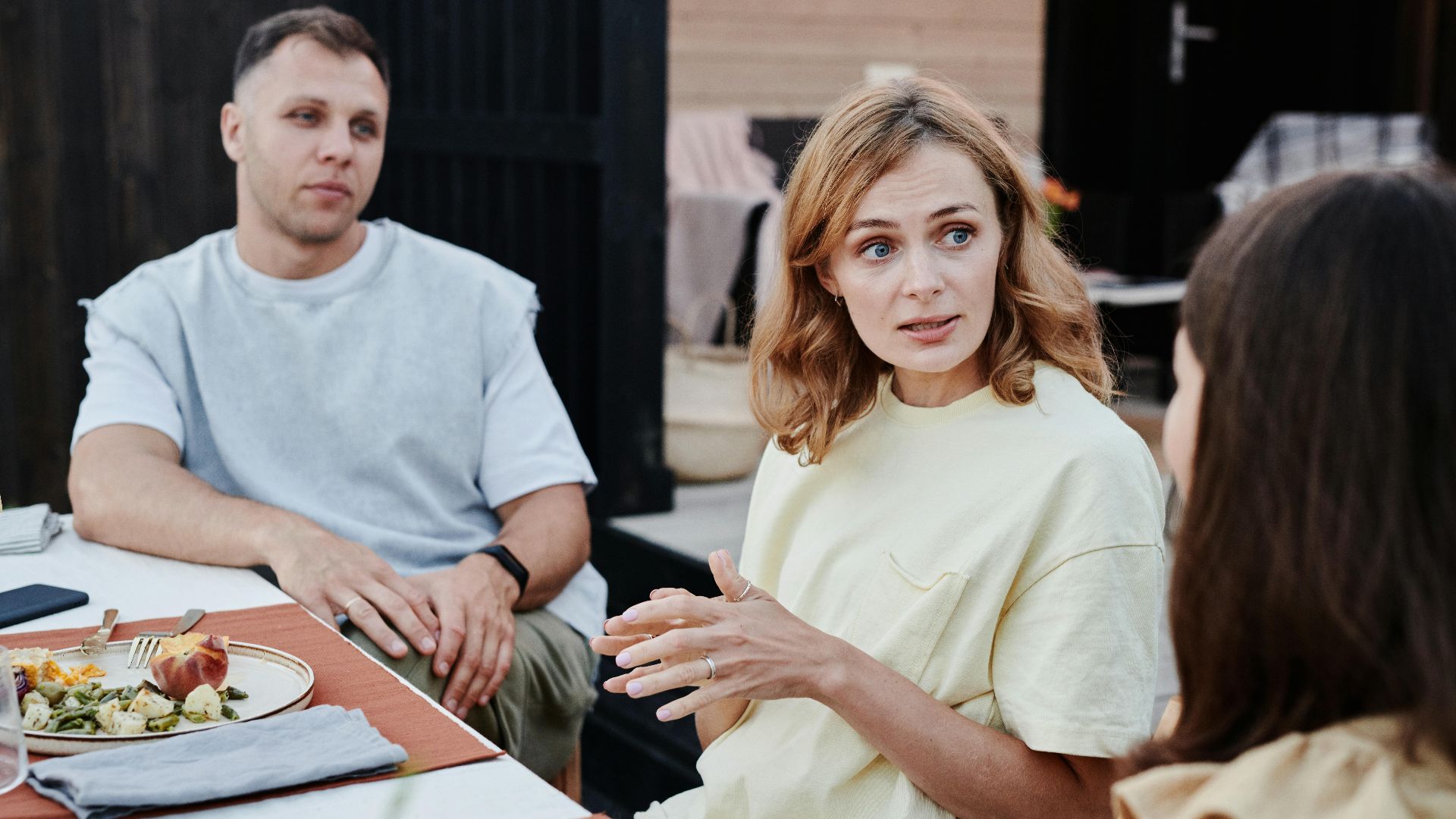A group of adults enjoying a relaxed outdoor meal together.