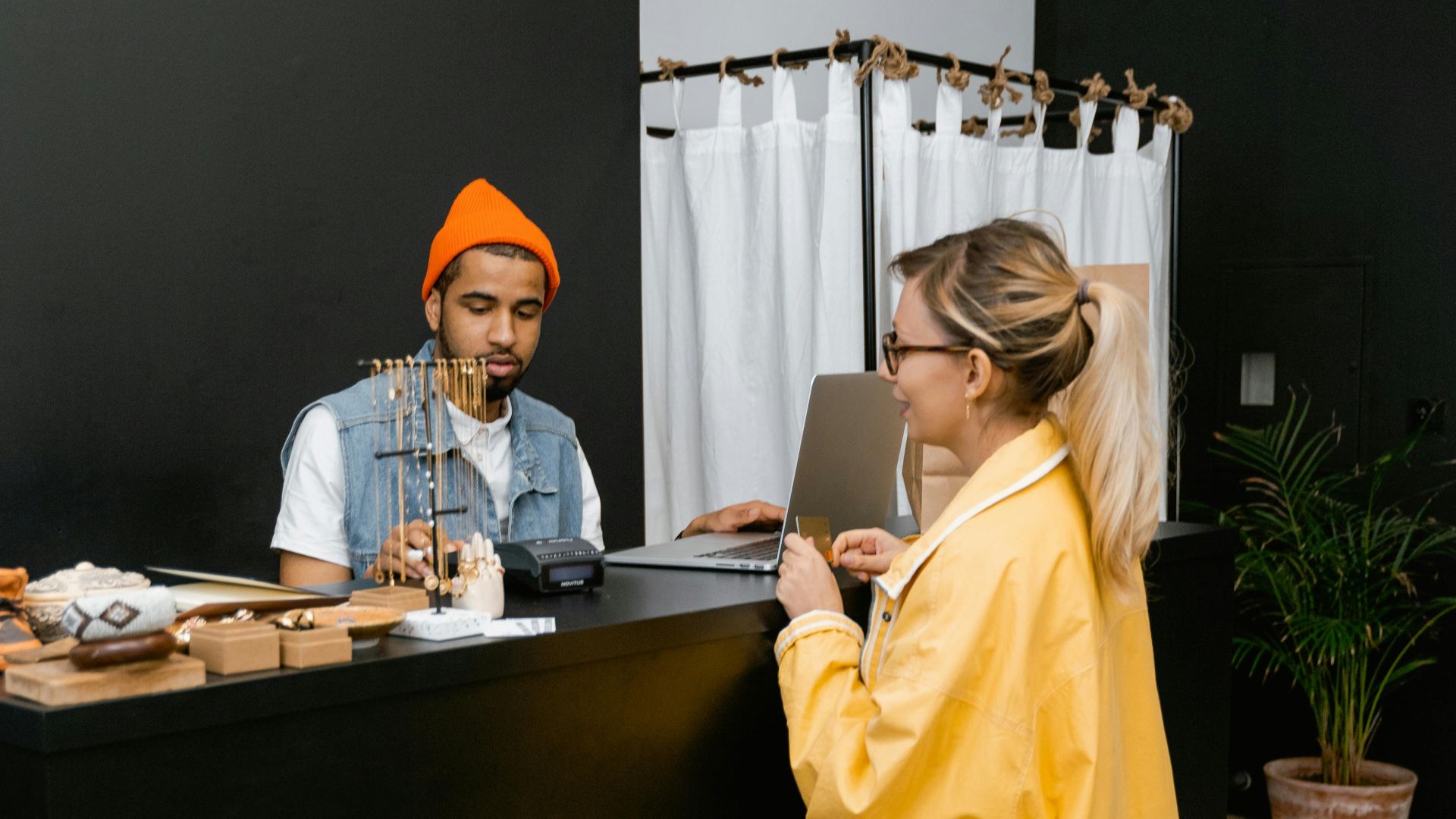 Indoor retail transaction with diverse employees and customers using cashless payment.