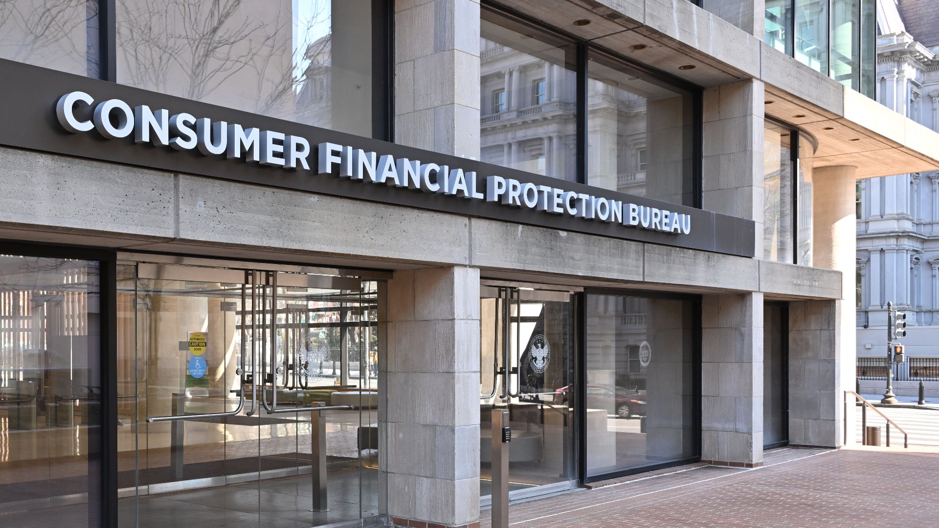 The entrance to the Consumer Financial Protection Bureau headquarters with the bureau's name above it. 1700 G Street NW, Washington, DC 20552.