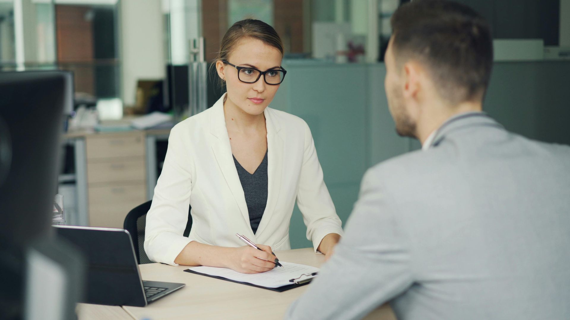 Two professionals in a serious business meeting at a modern office setting.