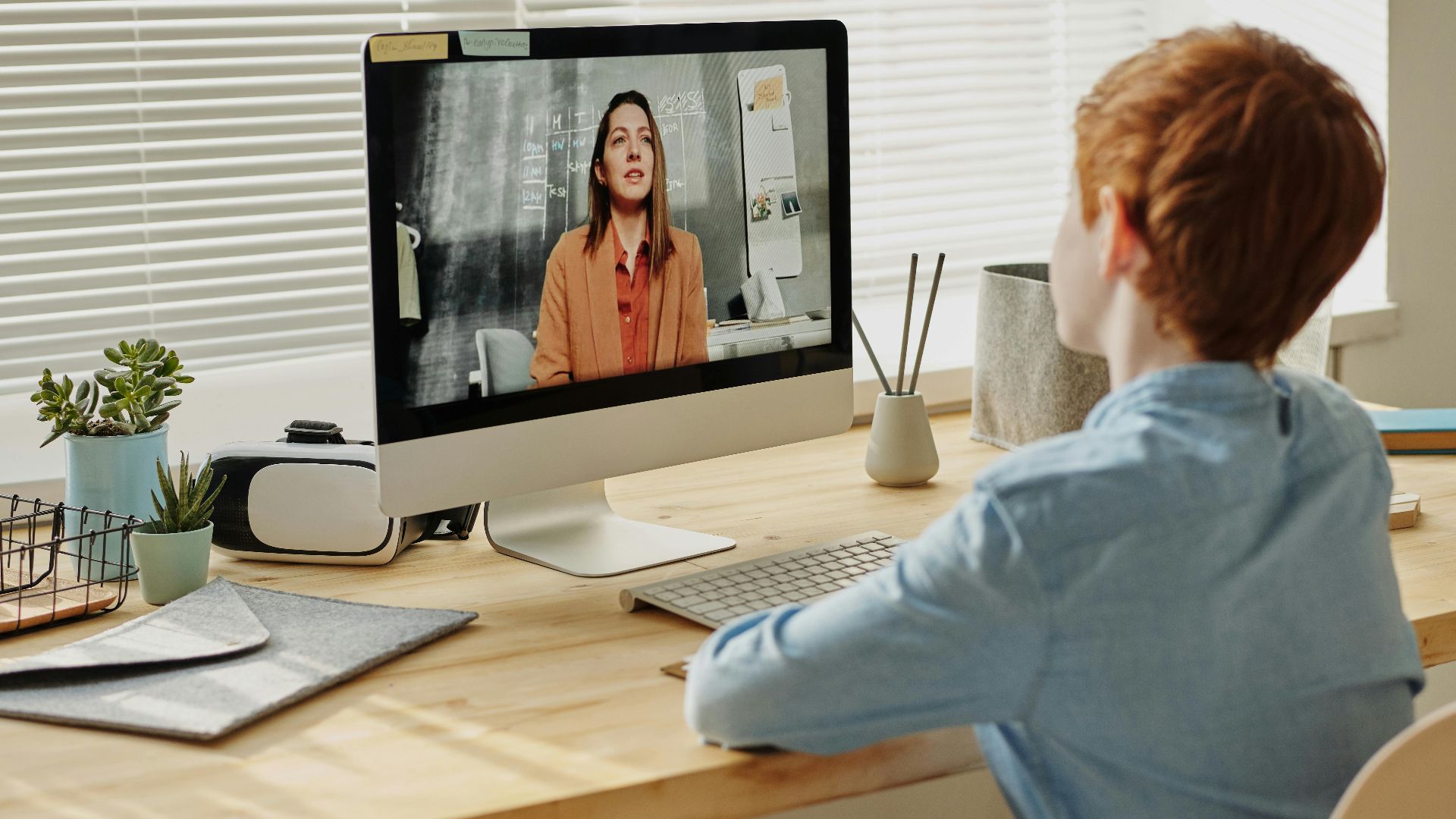Child attending an online class at home via computer, enhancing remote education.