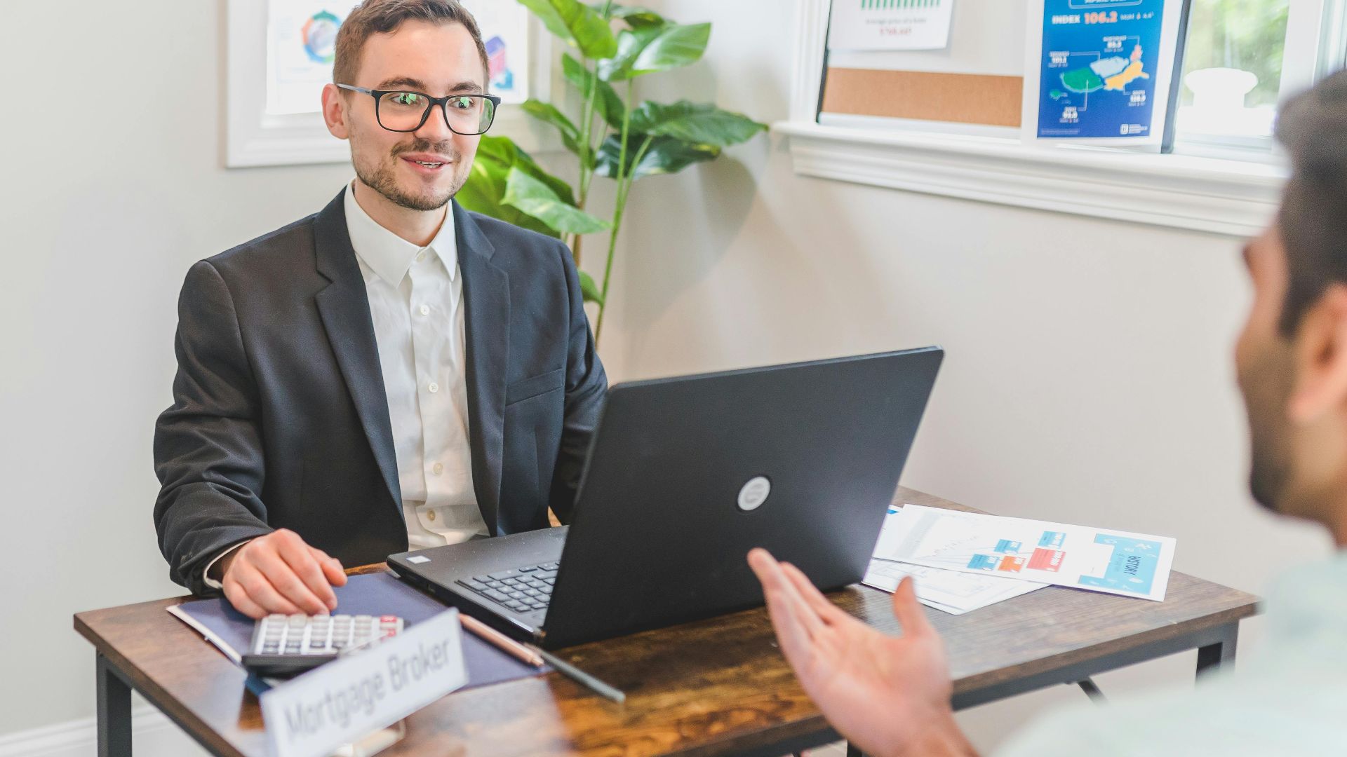 A mortgage broker and client discussing loan options in a modern office setting.