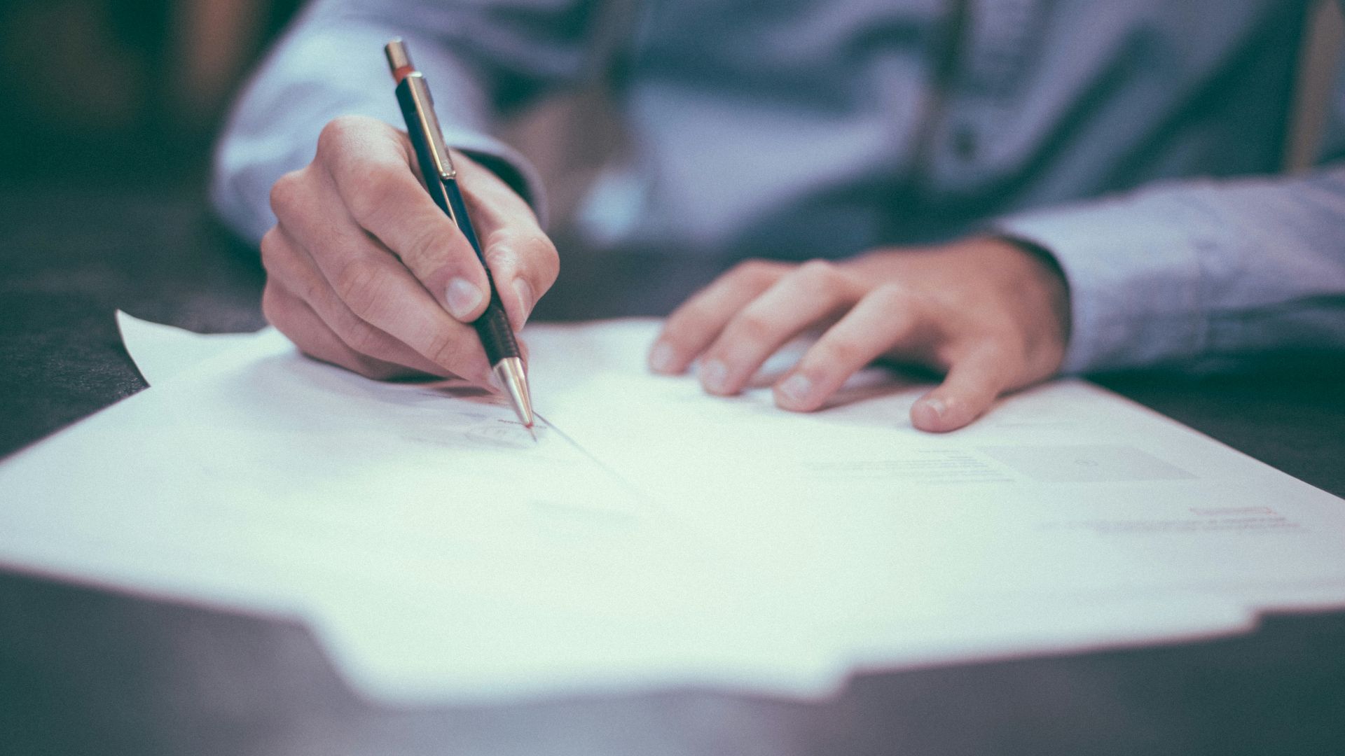 man writing on paper