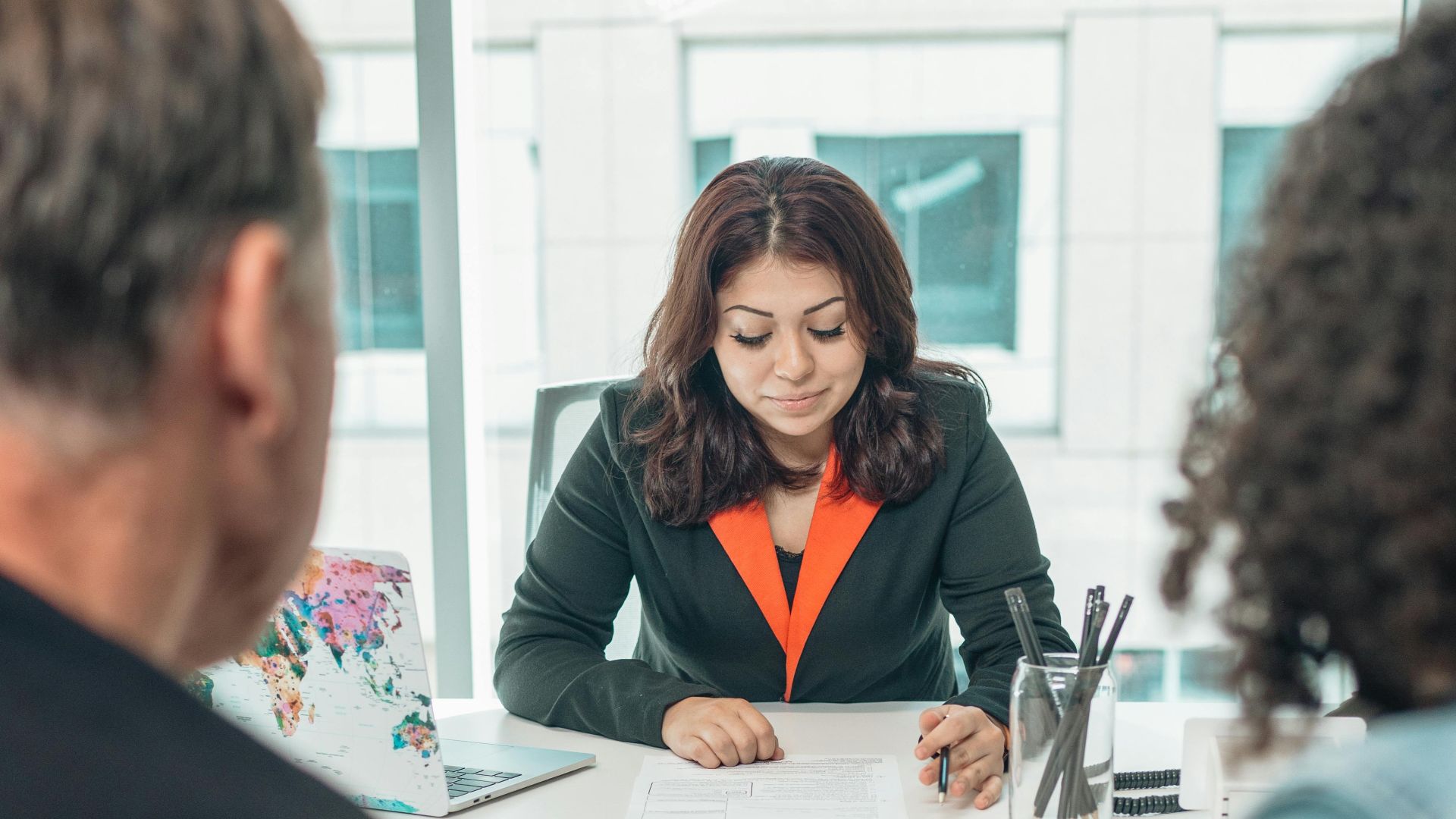 A couple signing adoption papers in an office with a lawyer's assistance.