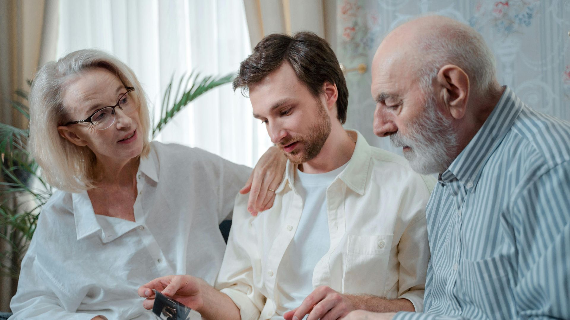 A family looks through a photo album, cherishing memories together indoors.