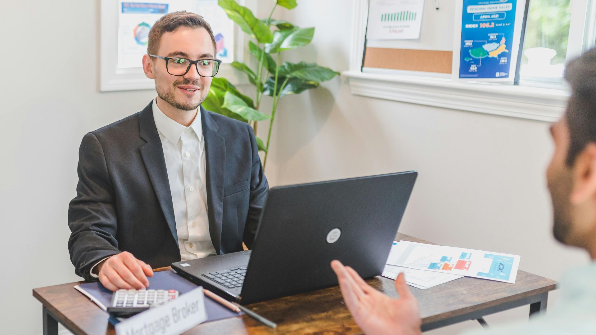 A mortgage broker and client discussing loan options in a modern office setting.