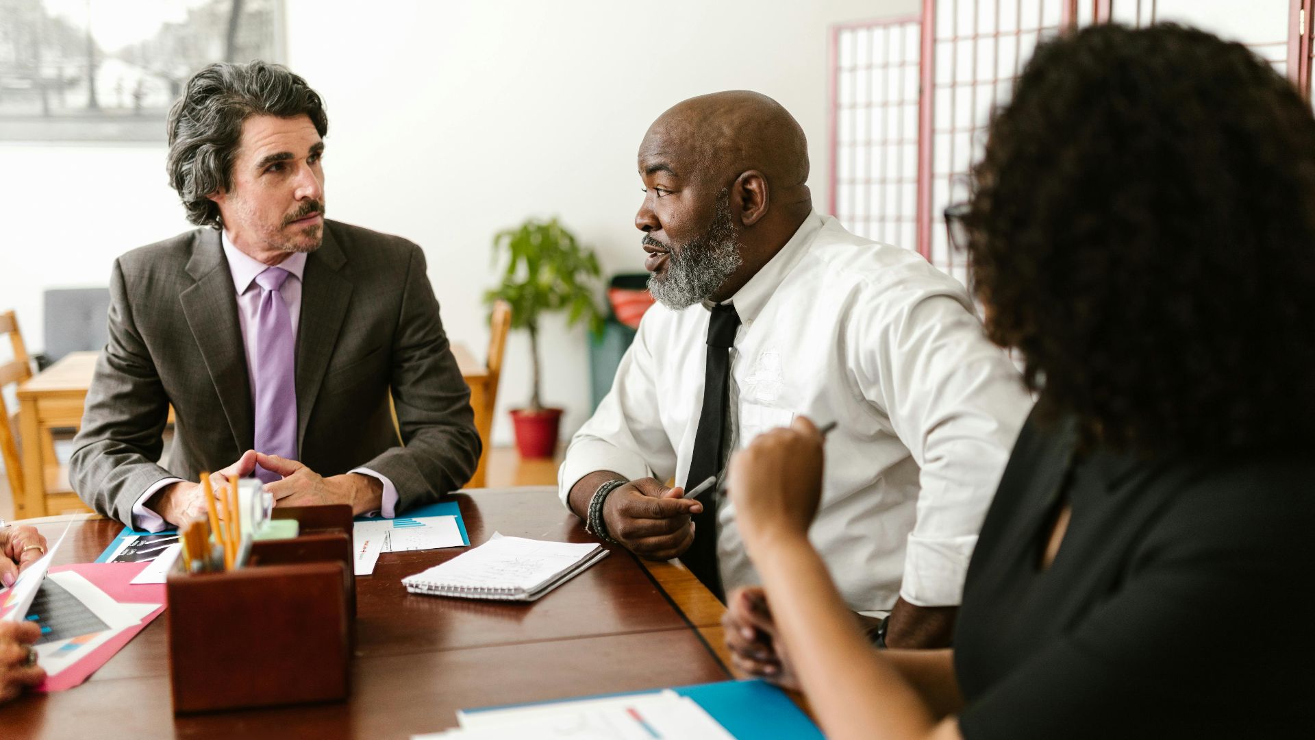 Diverse team of colleagues discussing at a workplace meeting.