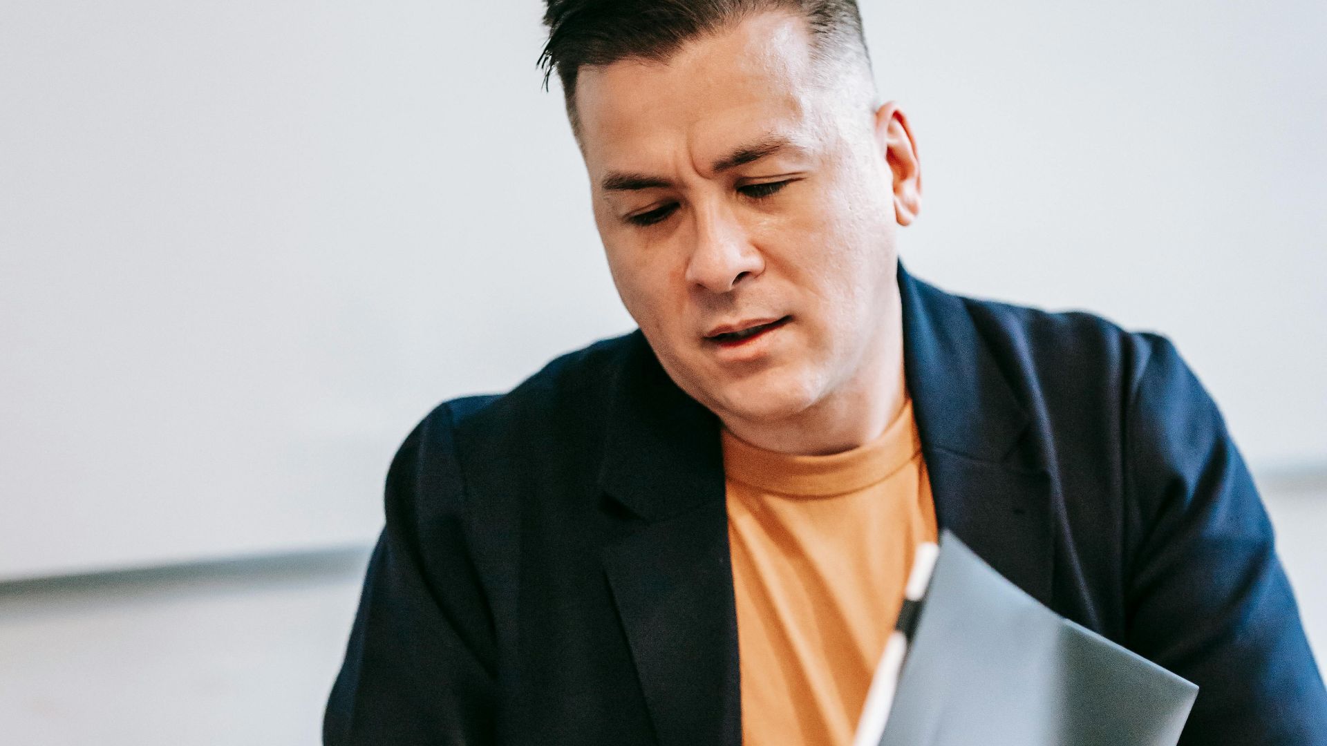 Businessman in a suit reviewing documents at an office desk, focused on work.