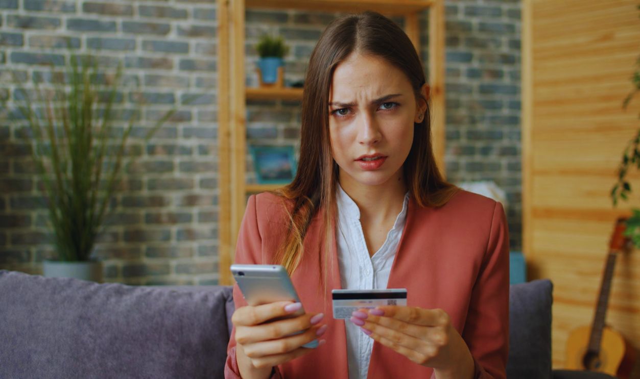 Confused Woman With Phone And Card