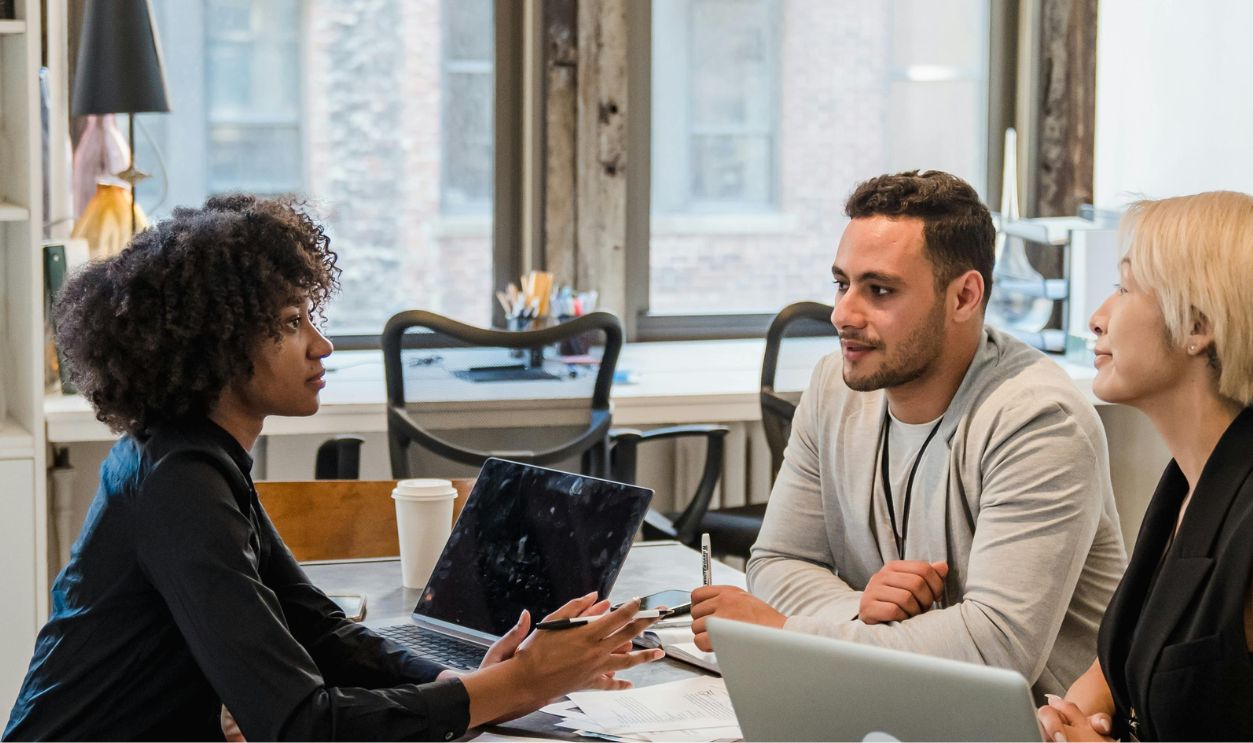 Employees Sitting at Desk Brainstorming 