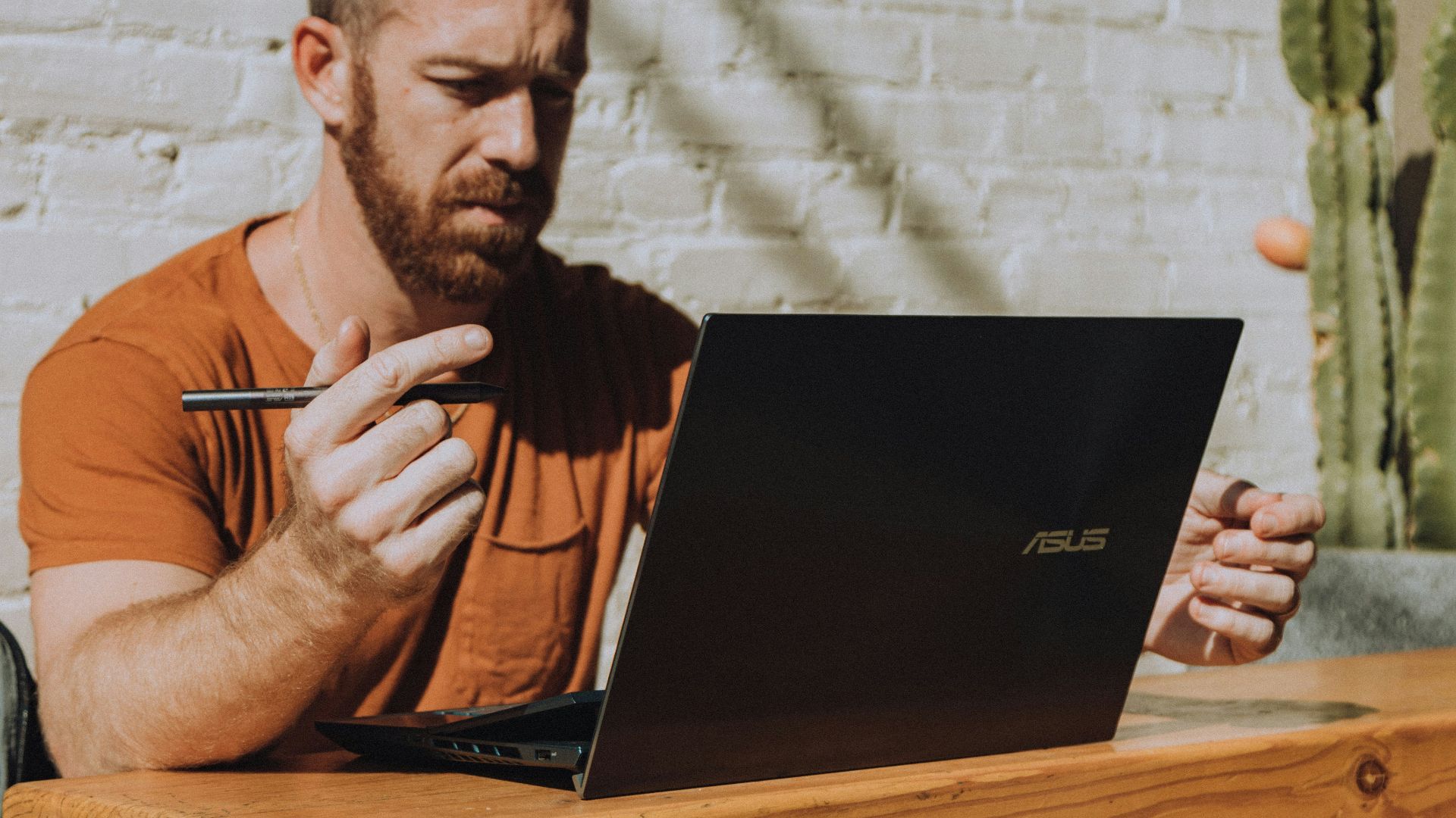 a man sitting at a table using a laptop computer