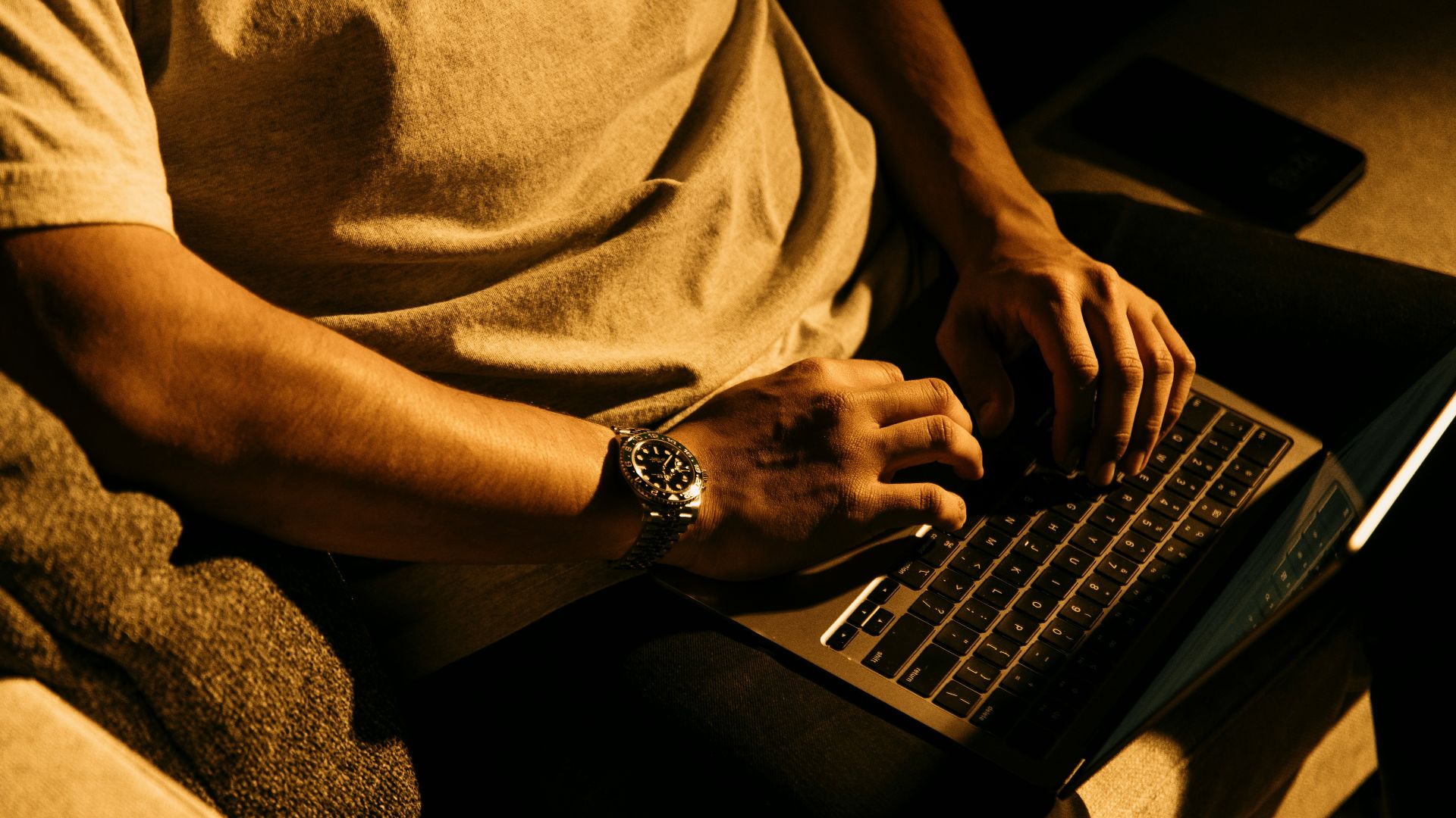 a man sitting on a couch using a laptop computer