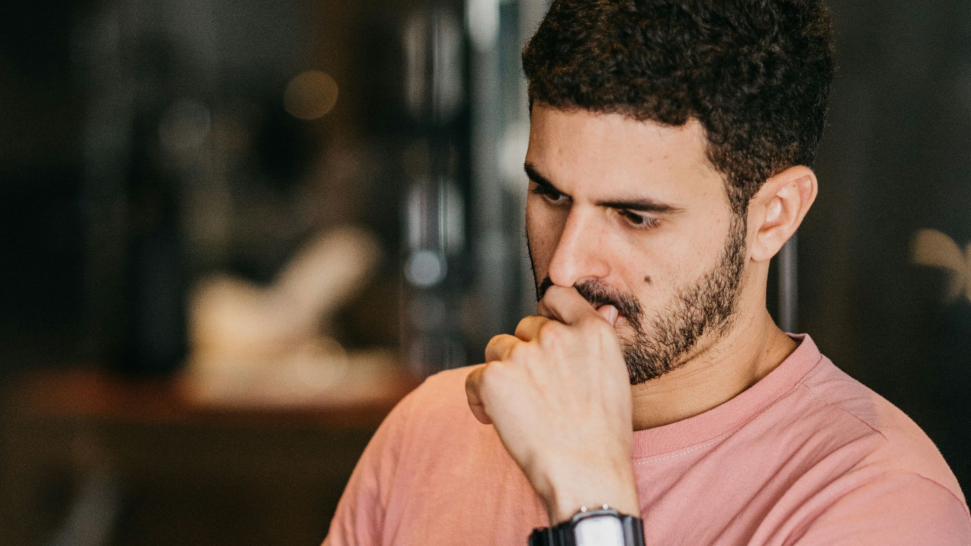 a man sitting at a table with a laptop and a cup