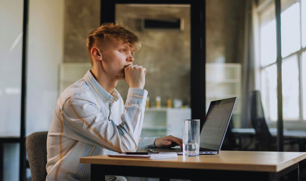 A Man in White Long Sleeves Using a Laptop
