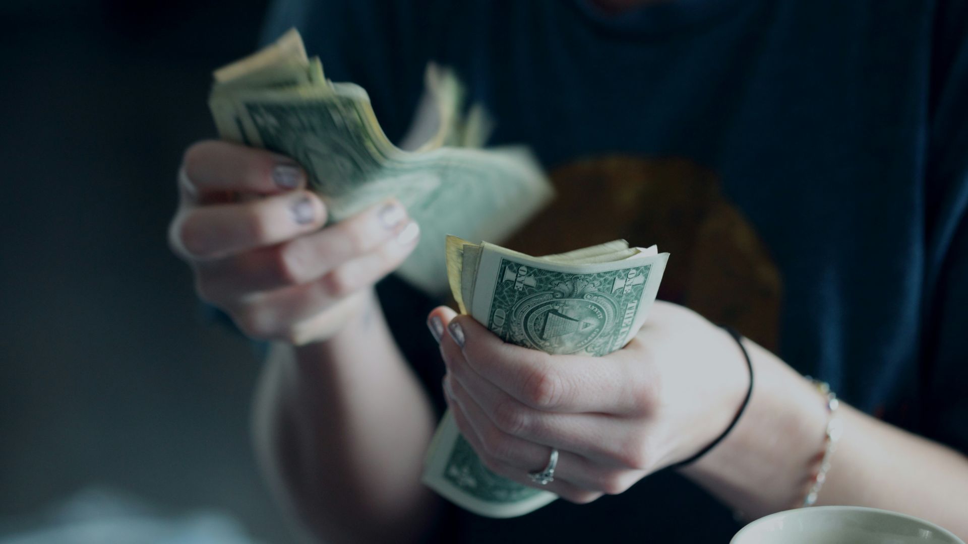 focus photography of person counting dollar banknotes
