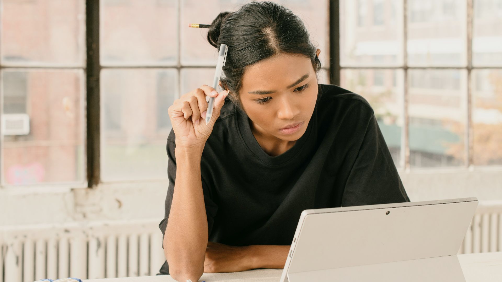 a woman sitting at a table using a laptop computer