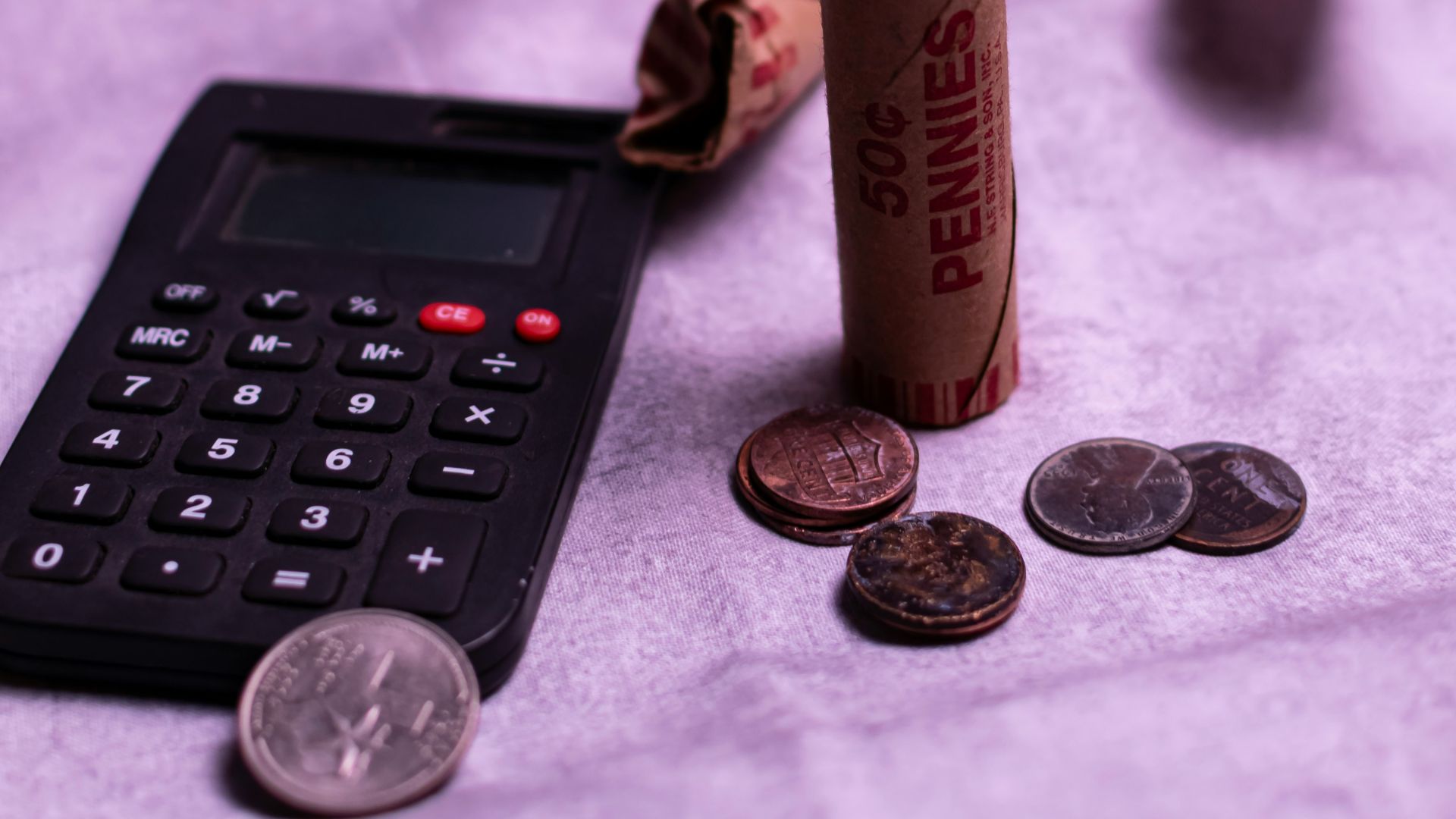 Calculator and rolls of pennies with loose coins.