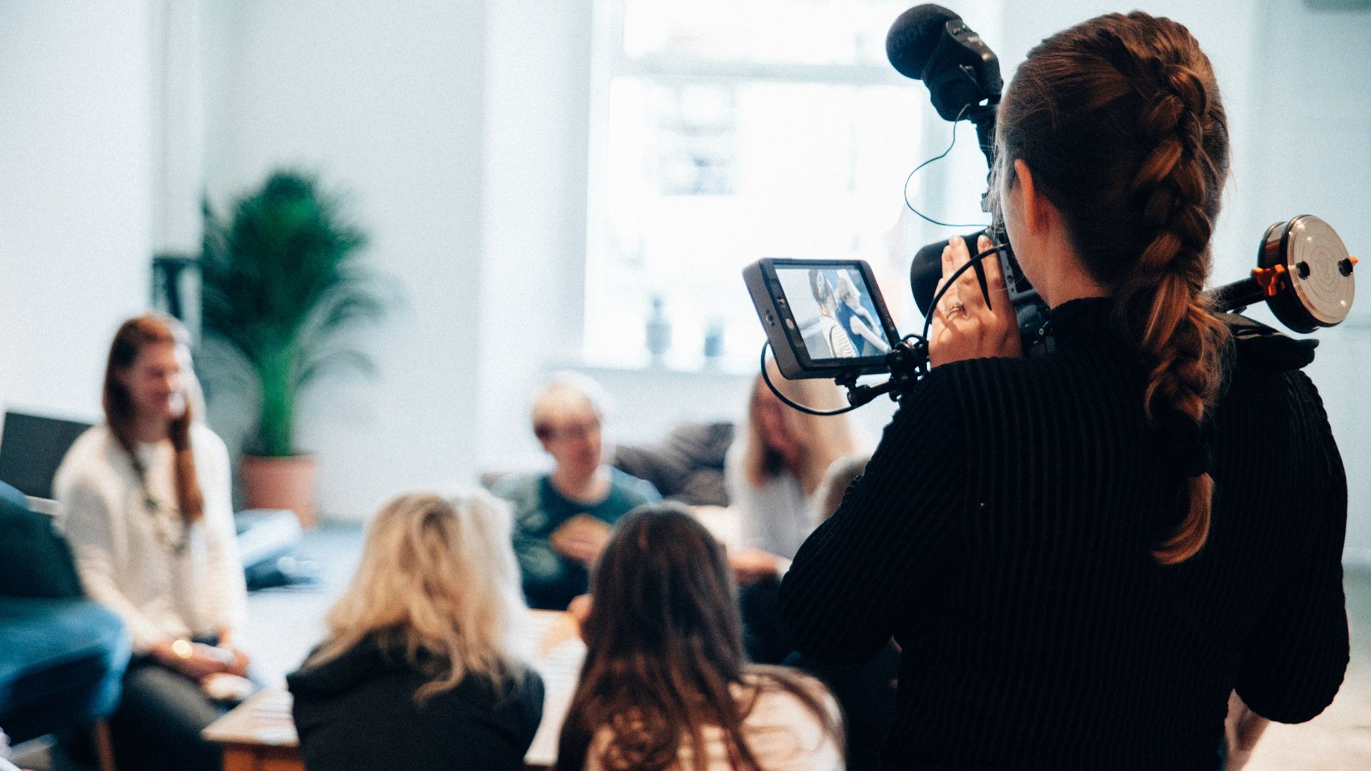 woman holding camera standing near people