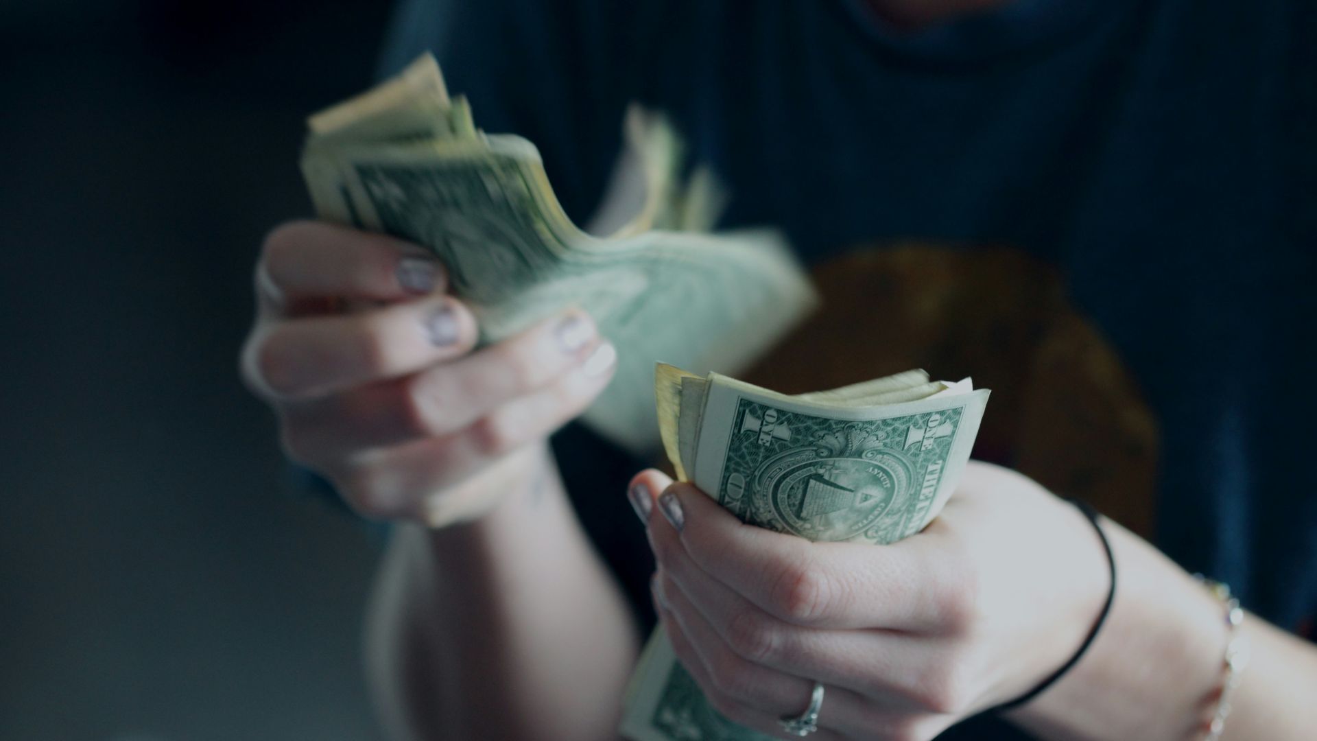 focus photography of person counting dollar banknotes
